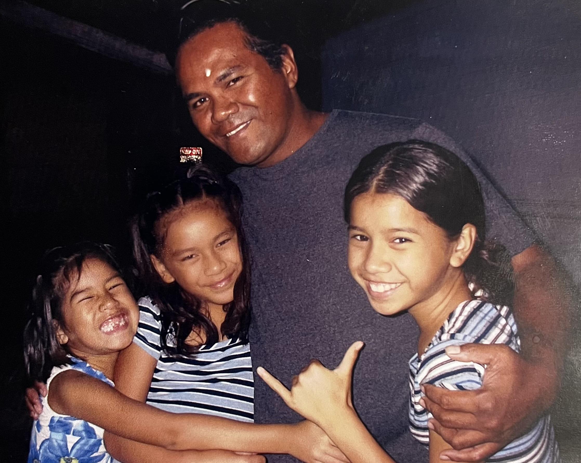 A man holding children and smiling