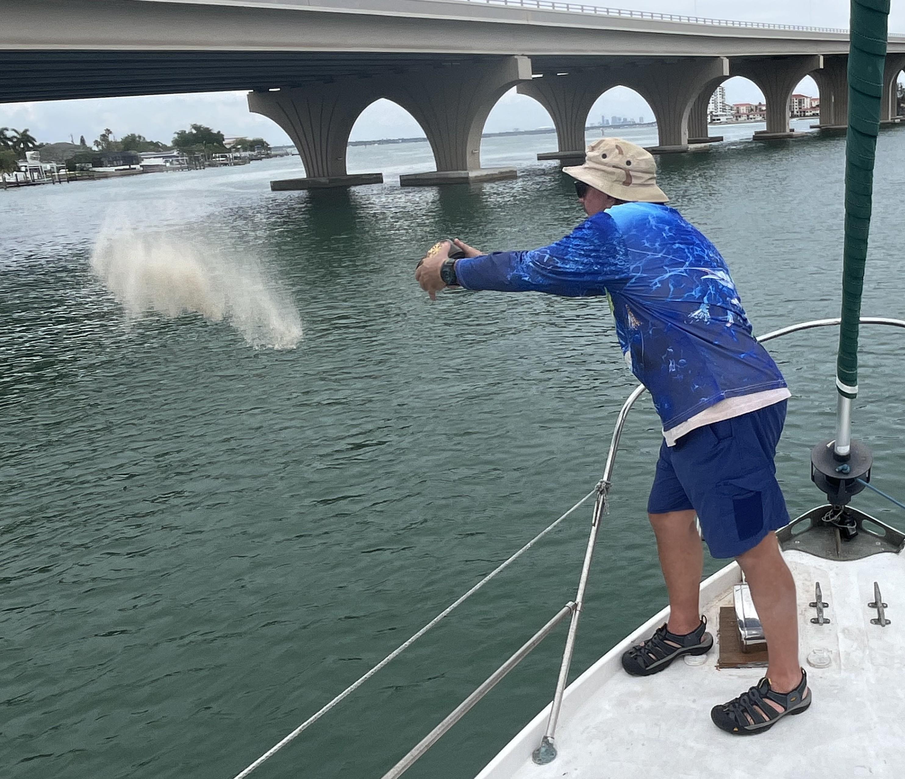 A man throwing sand into the water