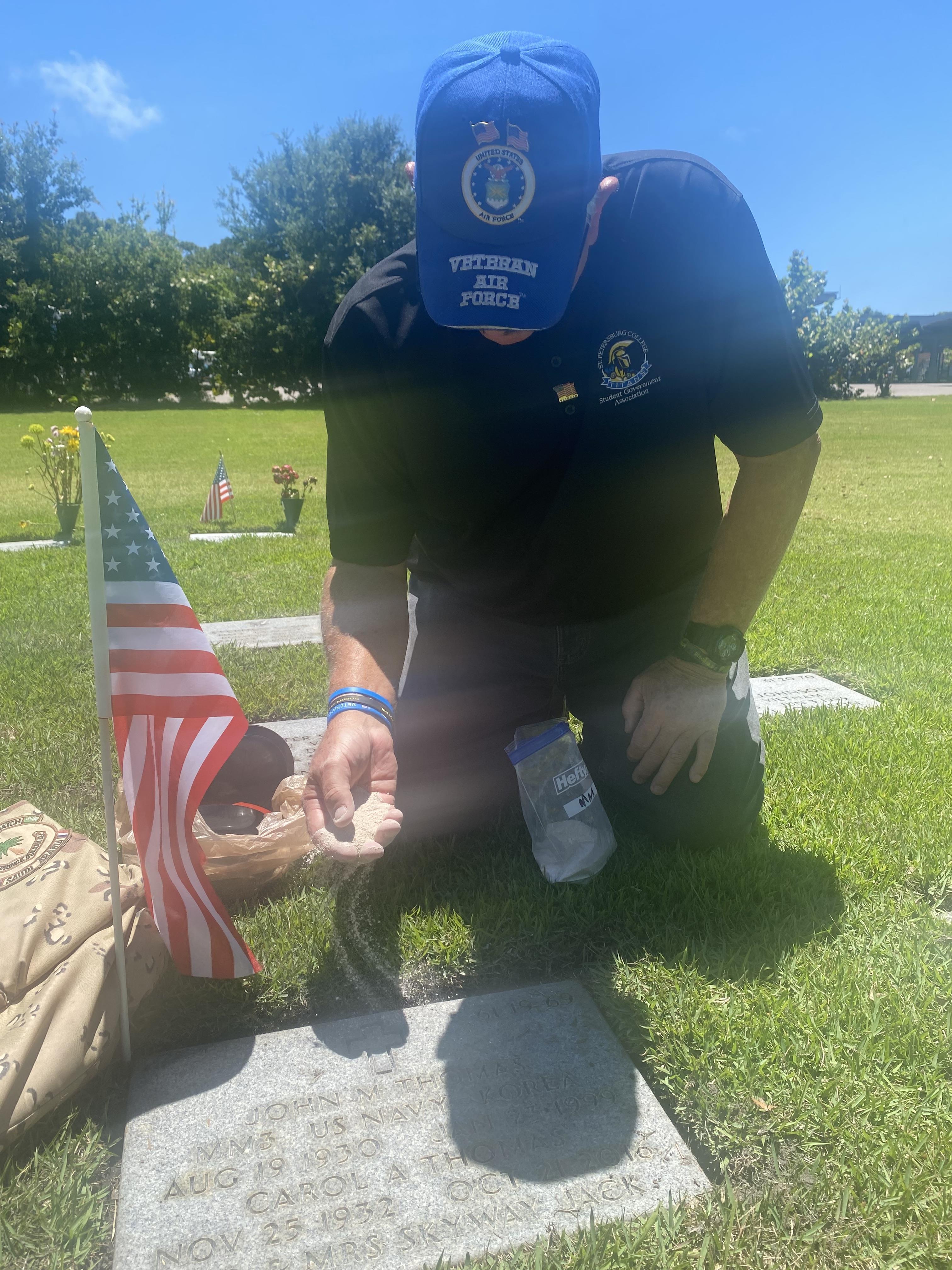 A man kneeling in a cemetery