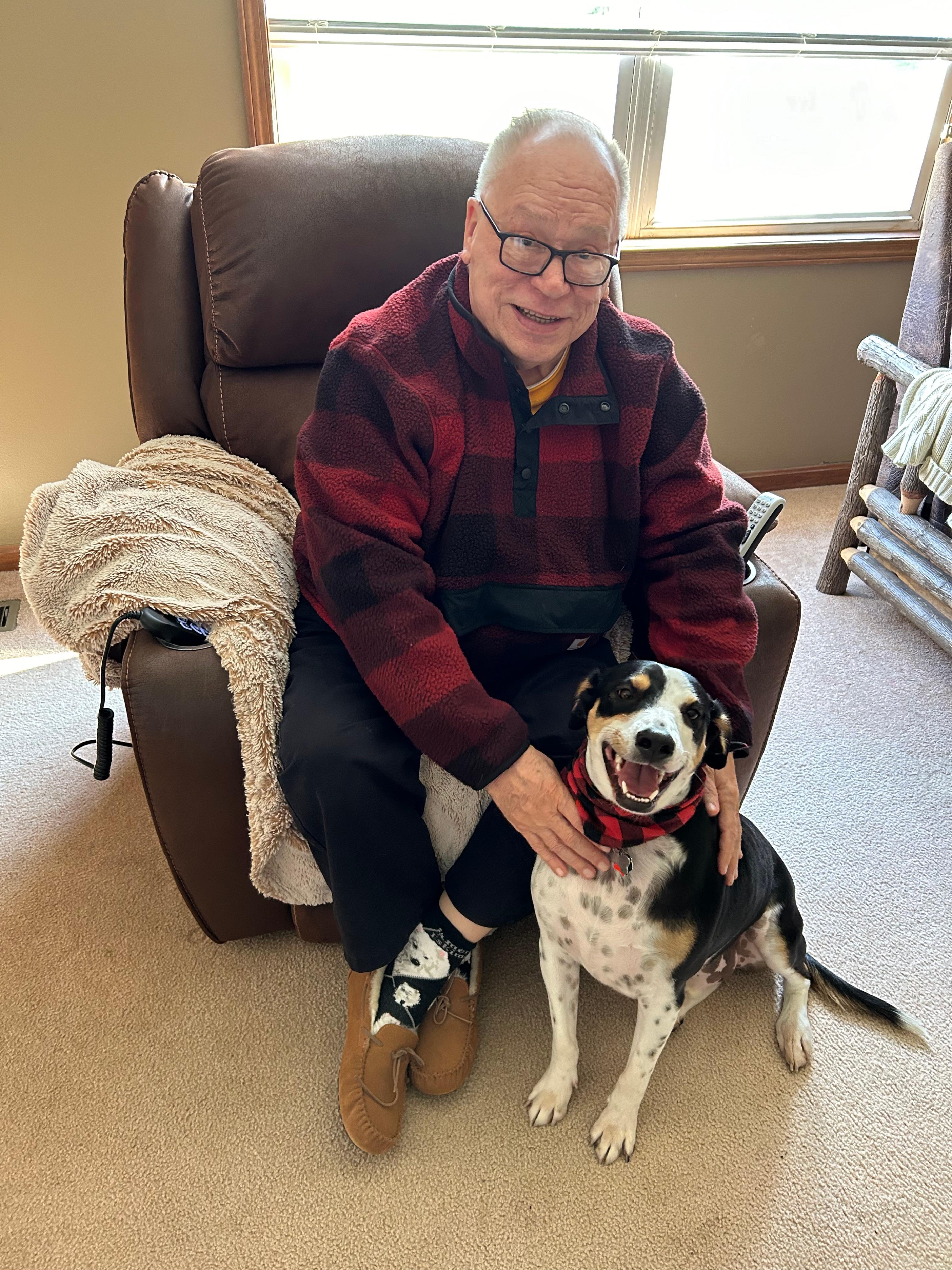 A man sitting in a chair with a dog