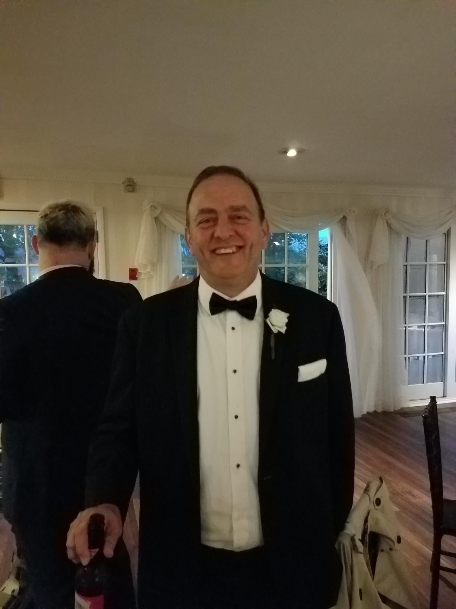 A man in a tuxedo smiling