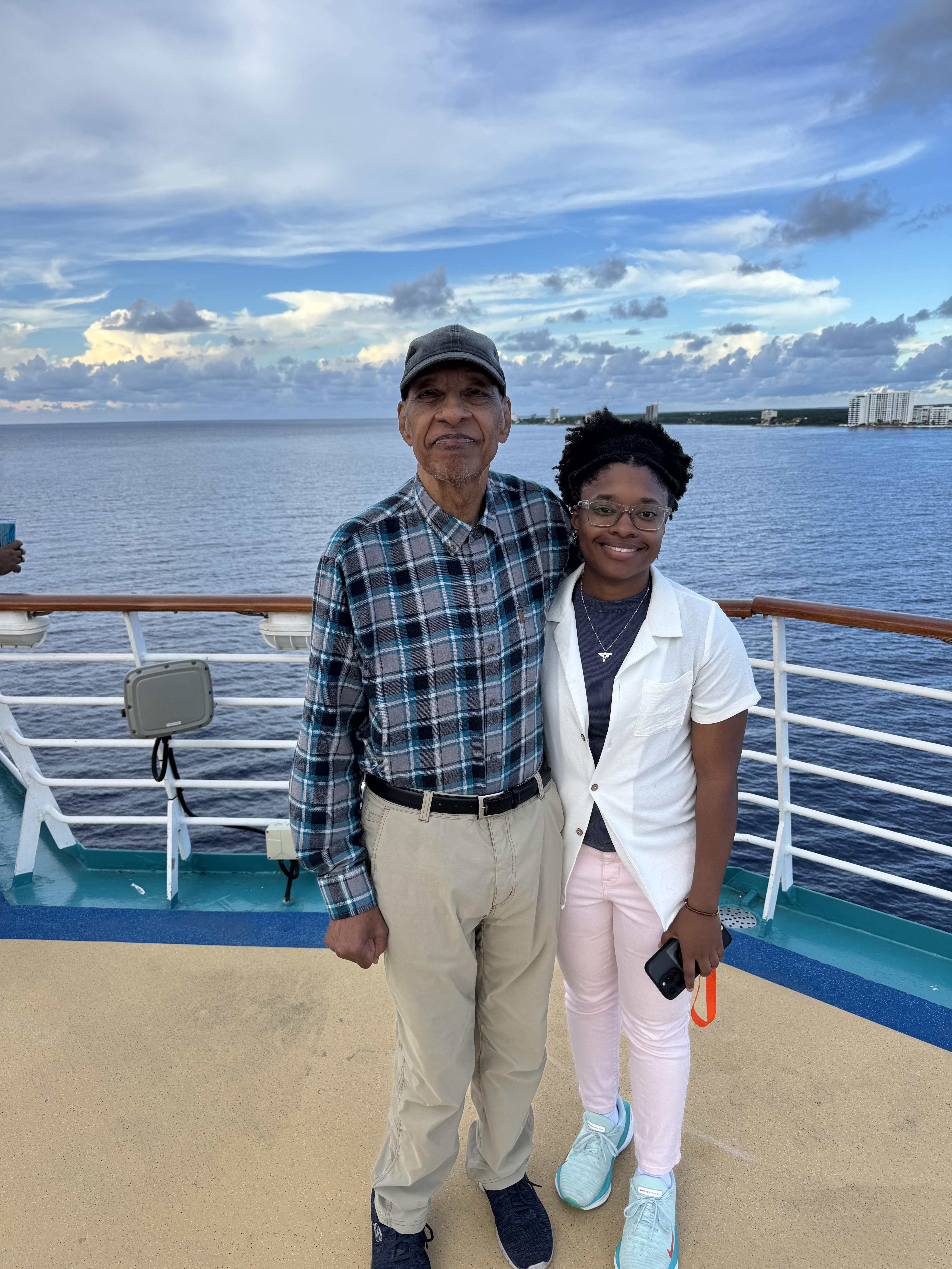 Two family members stand together on a cruise ship.