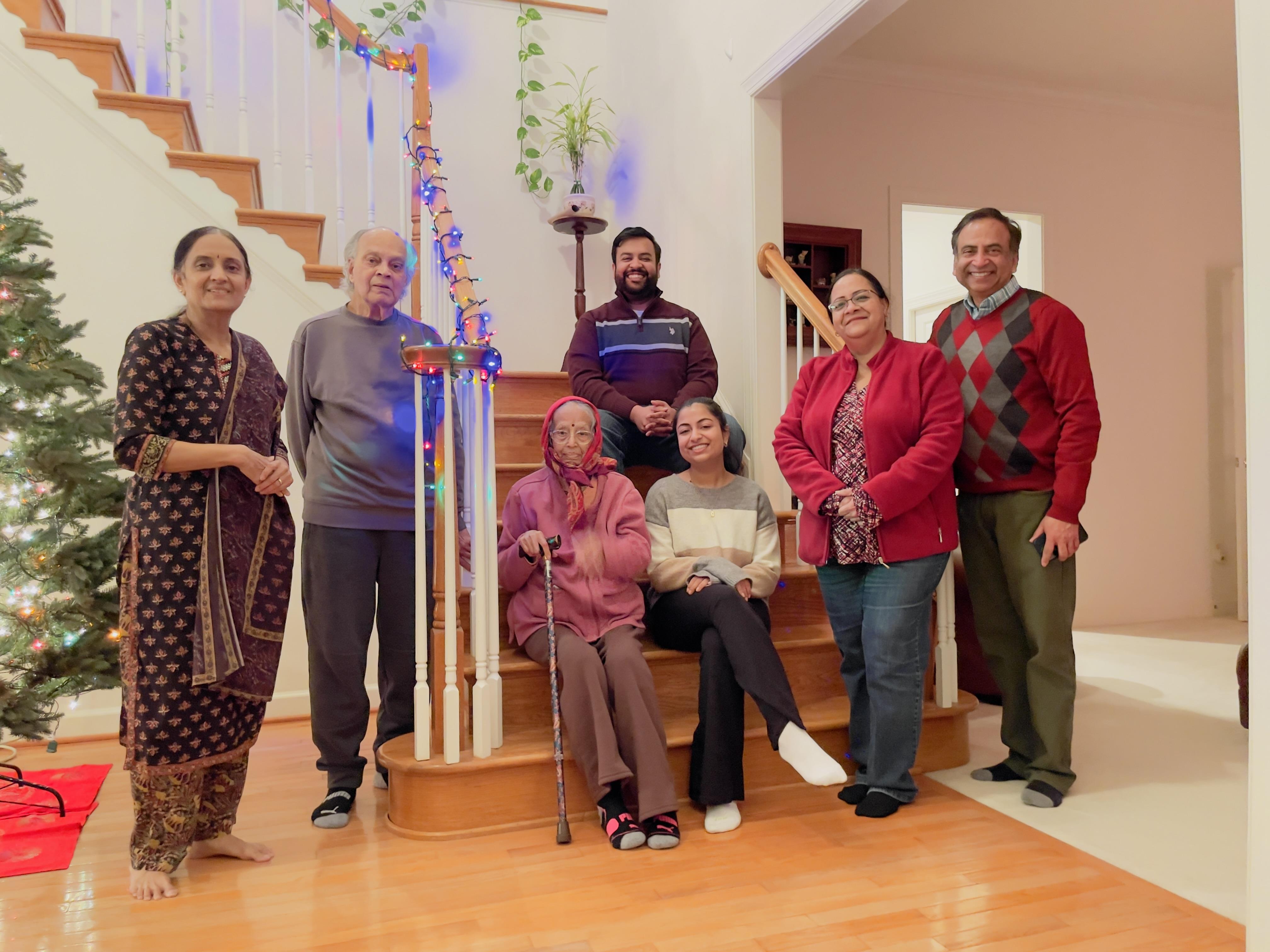 Family poses together on the staircase, celebrating a special occasion in their home.