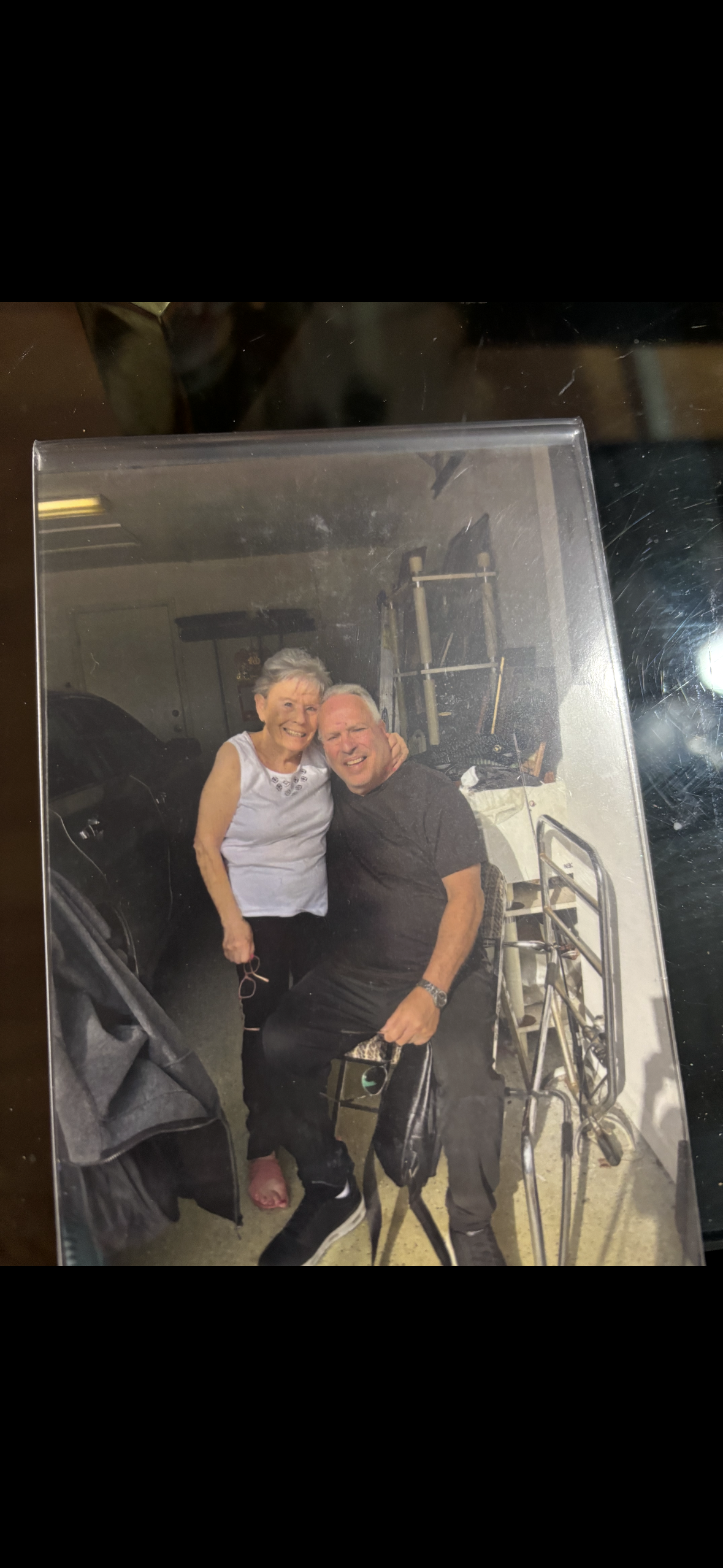 Two people sit side by side in a garage, enjoying their time together and smiling happily.