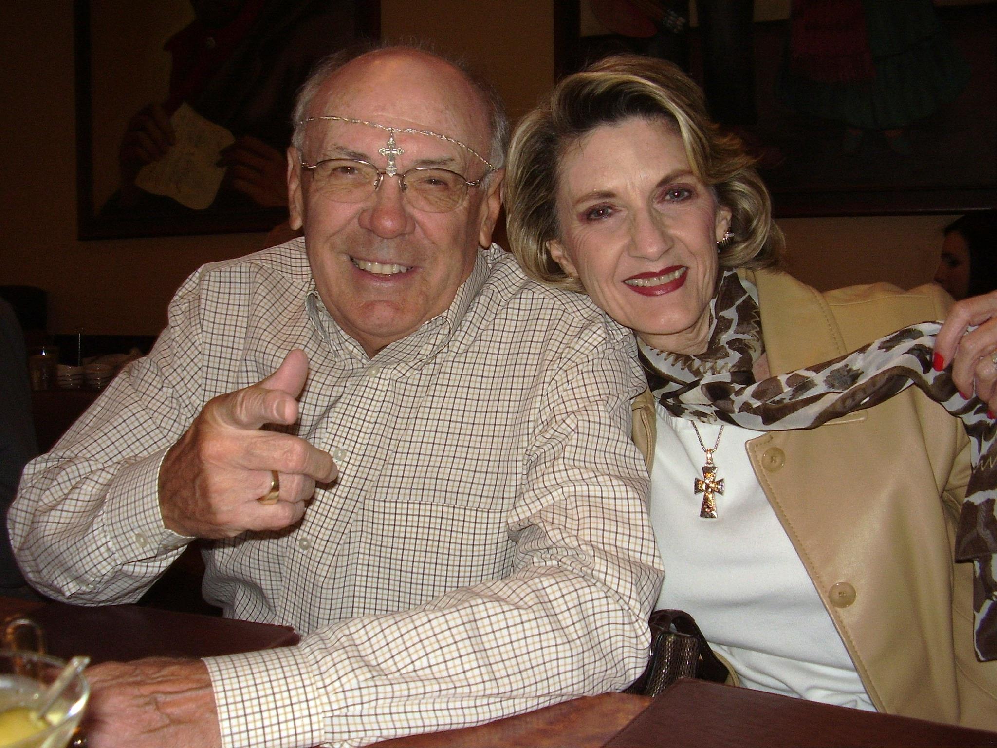 Two people pose happily at a table in a restaurant during a friendly get-together.