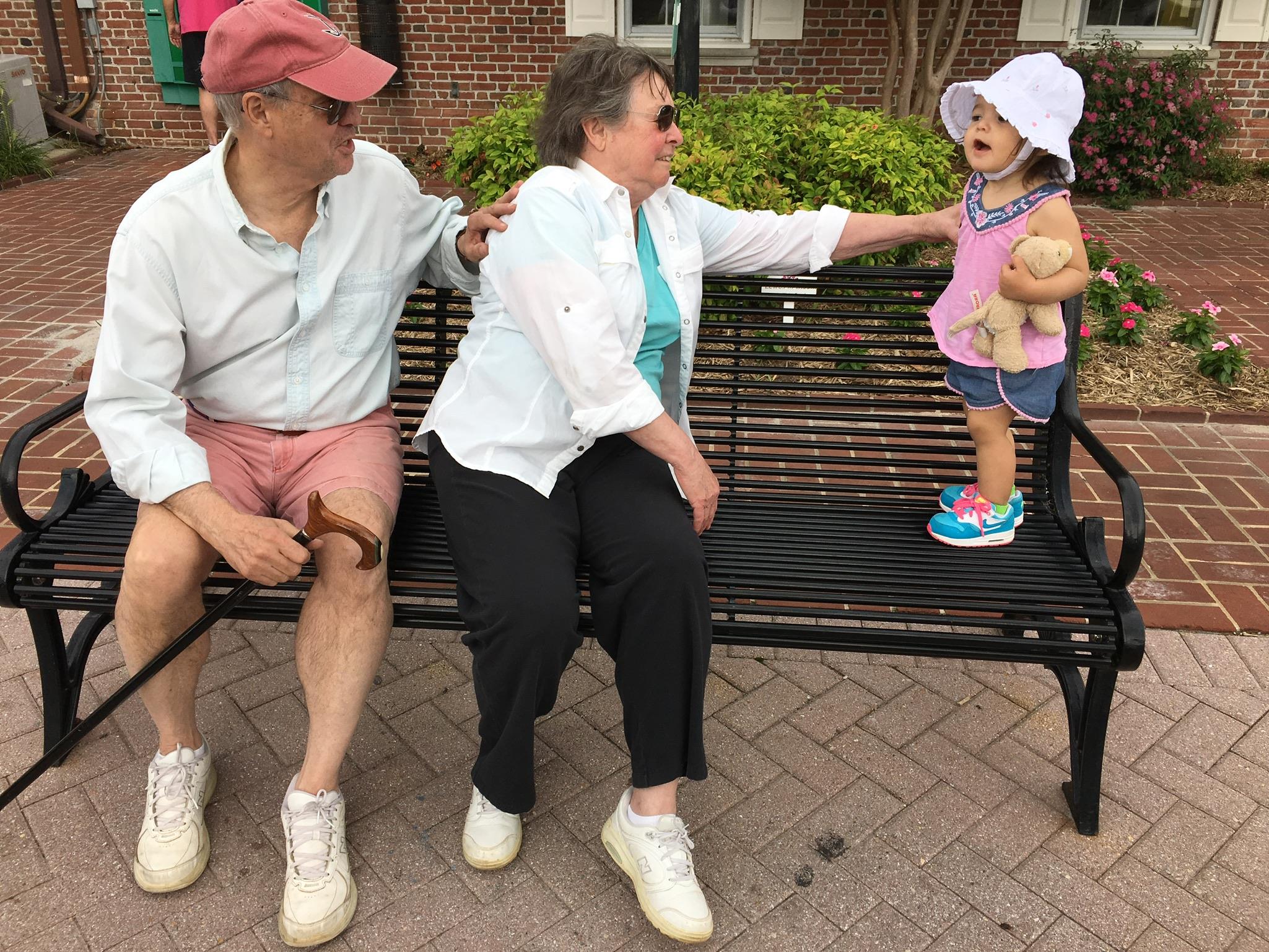 A man and woman sitting on a bench with a child