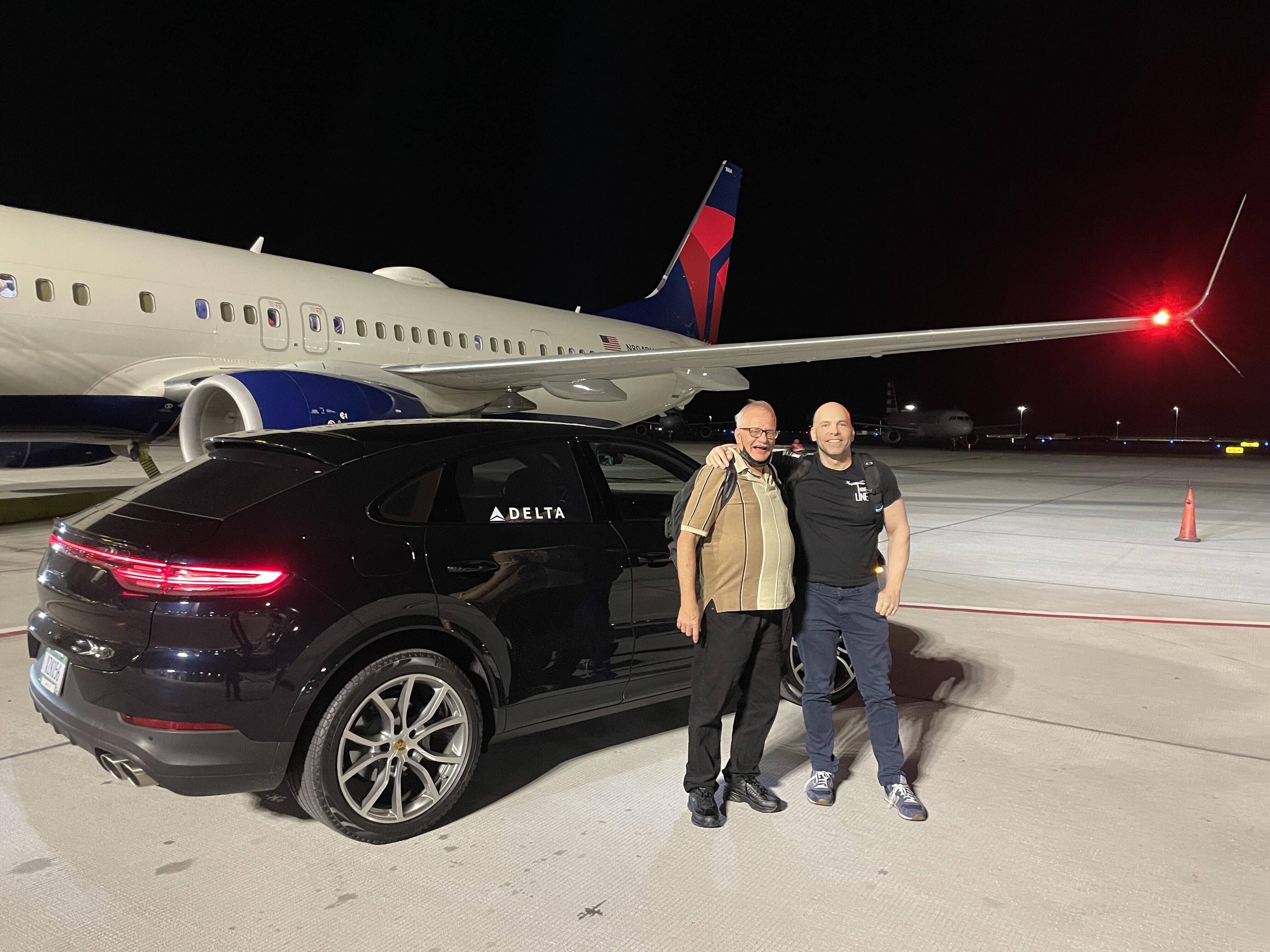 Two men standing in front of a plane
