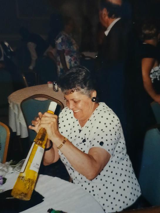 A woman opening a bottle of wine