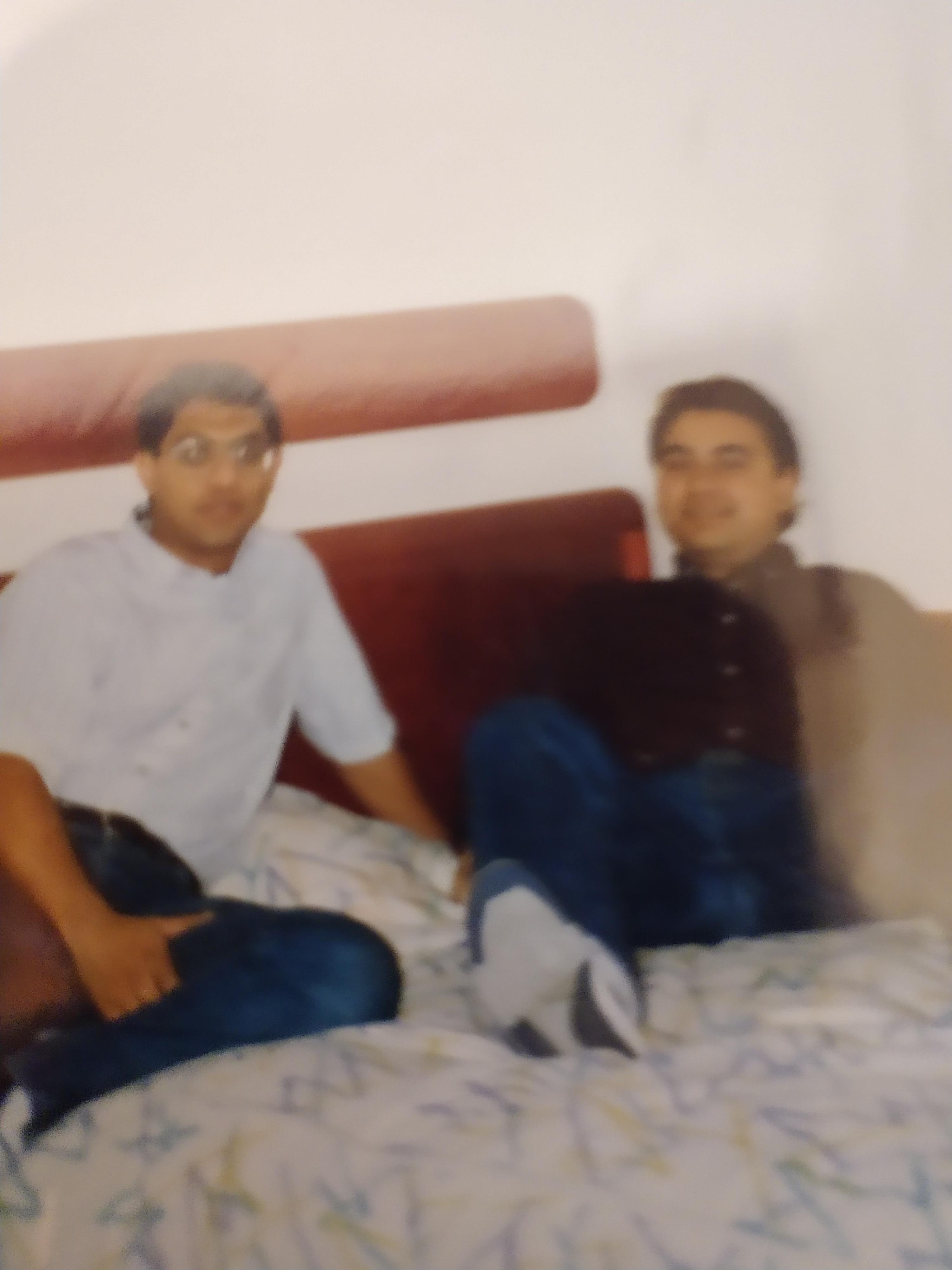 Two men sitting on a bed