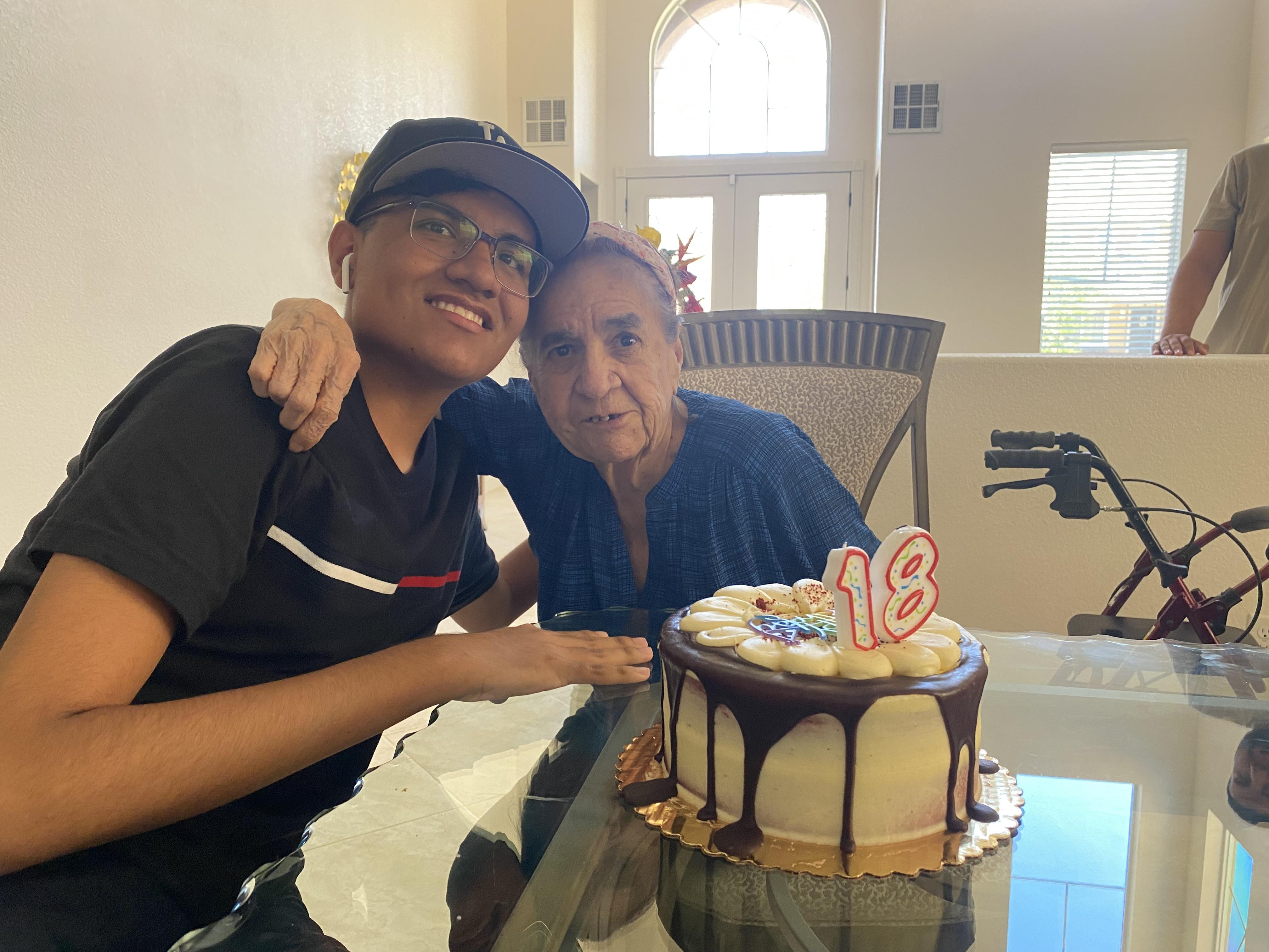 A man and woman sitting at a table with a cake
