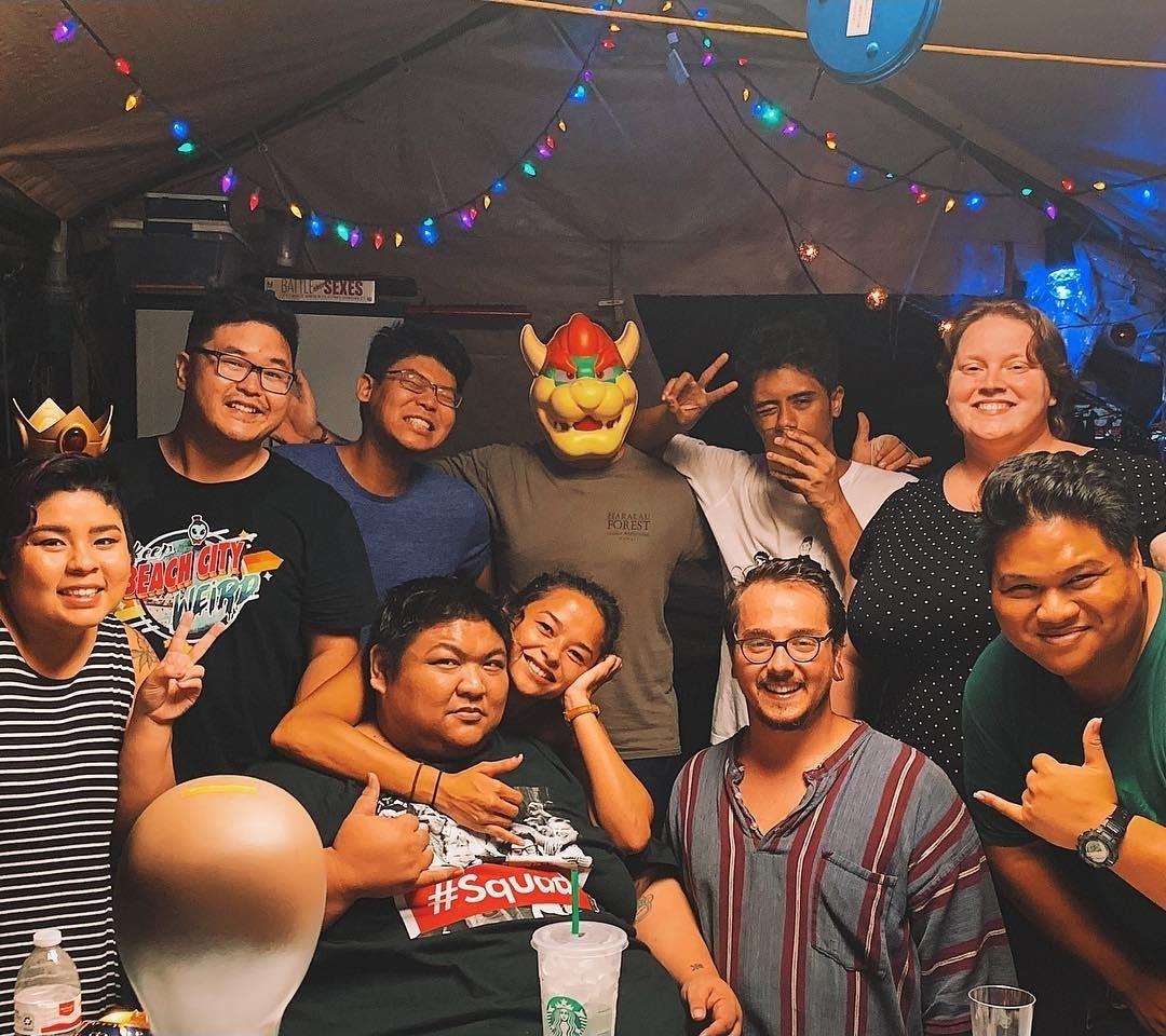 Friends gather at a party enjoying each other's company and posing for a group picture.