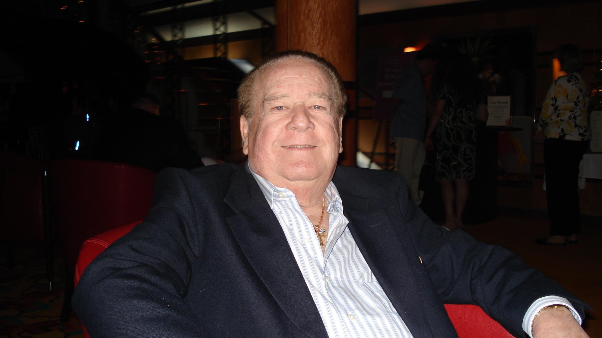 Man enjoys his time at a social event in a relaxed atmosphere with friends around him.