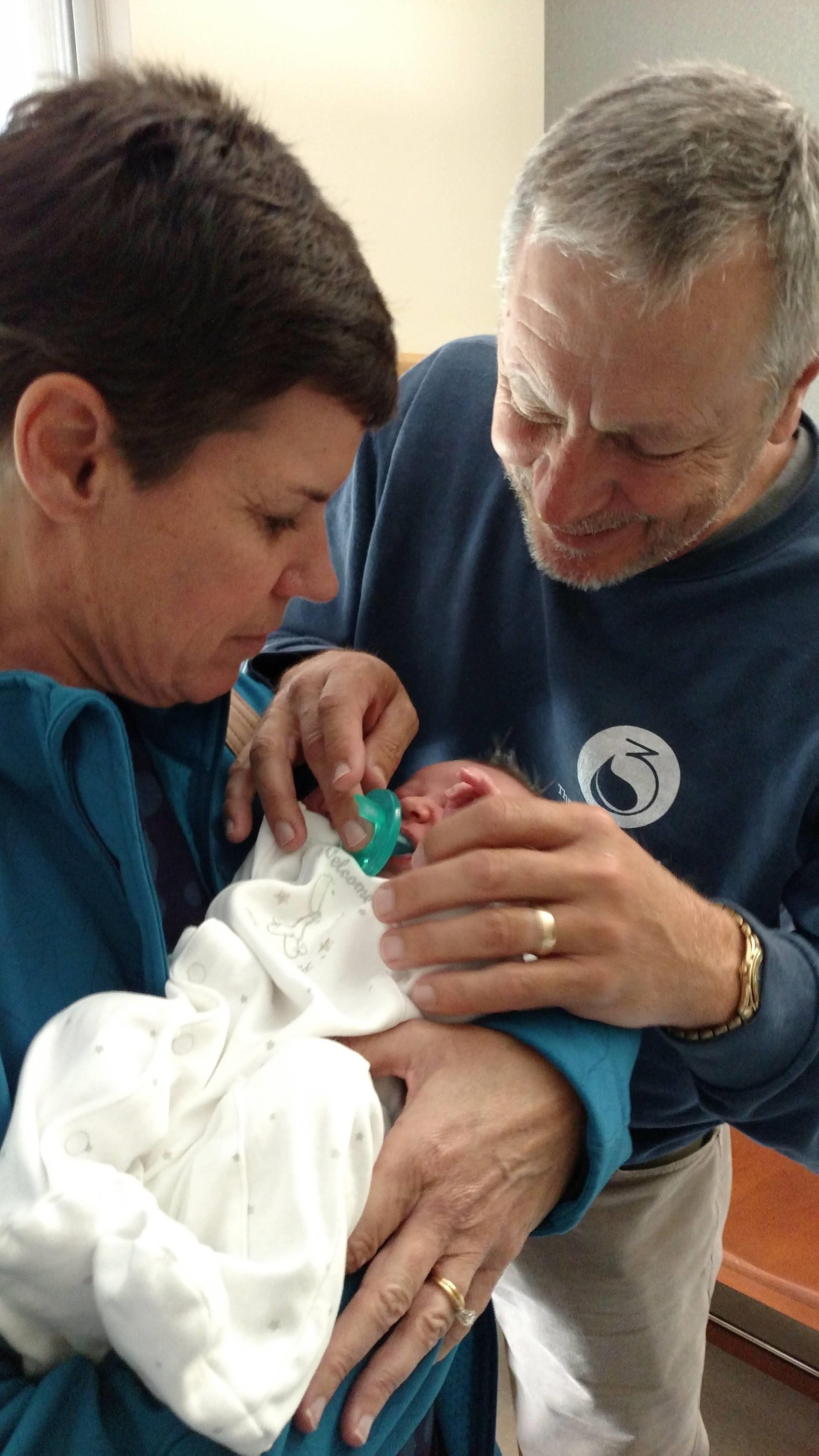 A couple cherishes their newborn in a joyful moment at home one afternoon.