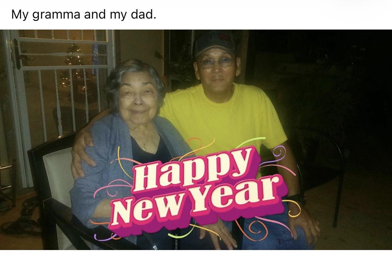 A son and his grandmother smile together while celebrating New Year with family at night.