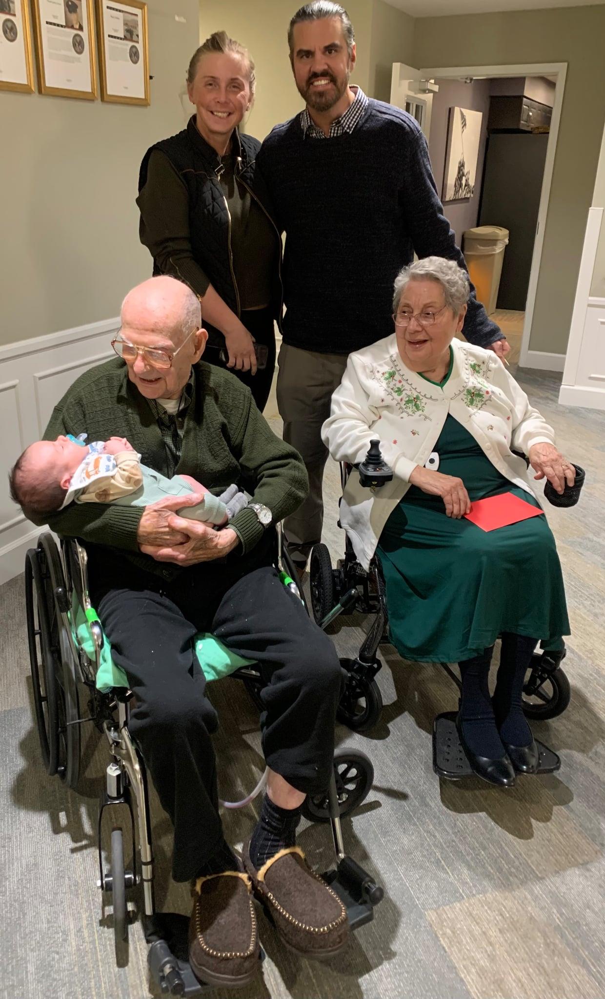 A man holding a baby in a wheelchair