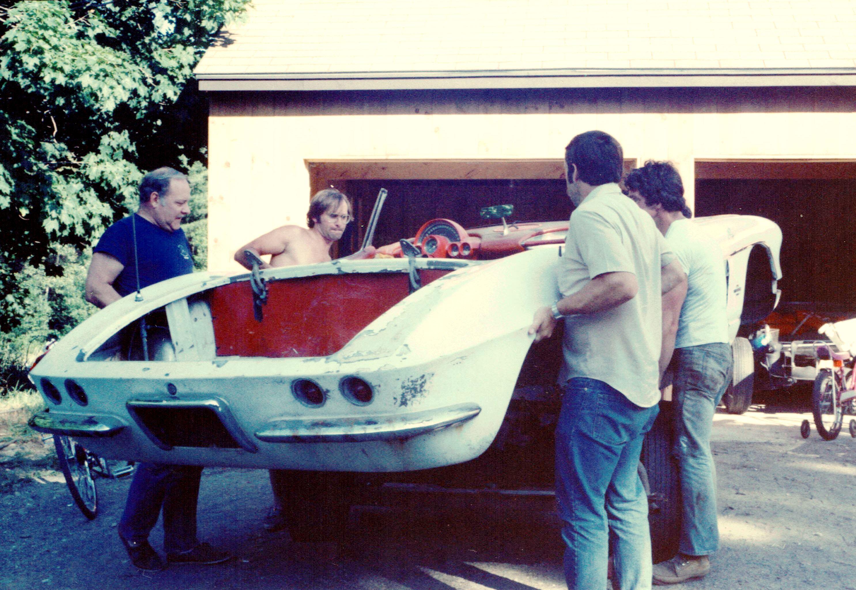 A group of men standing next to a car