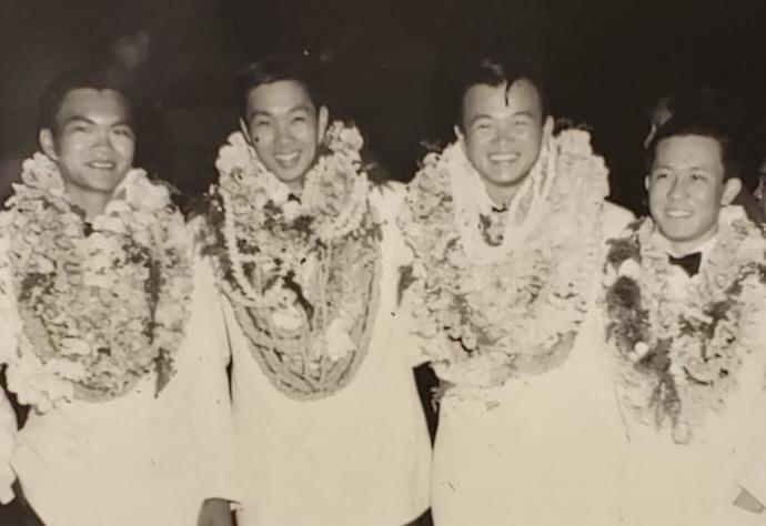 A group of men wearing white shirts and flowers