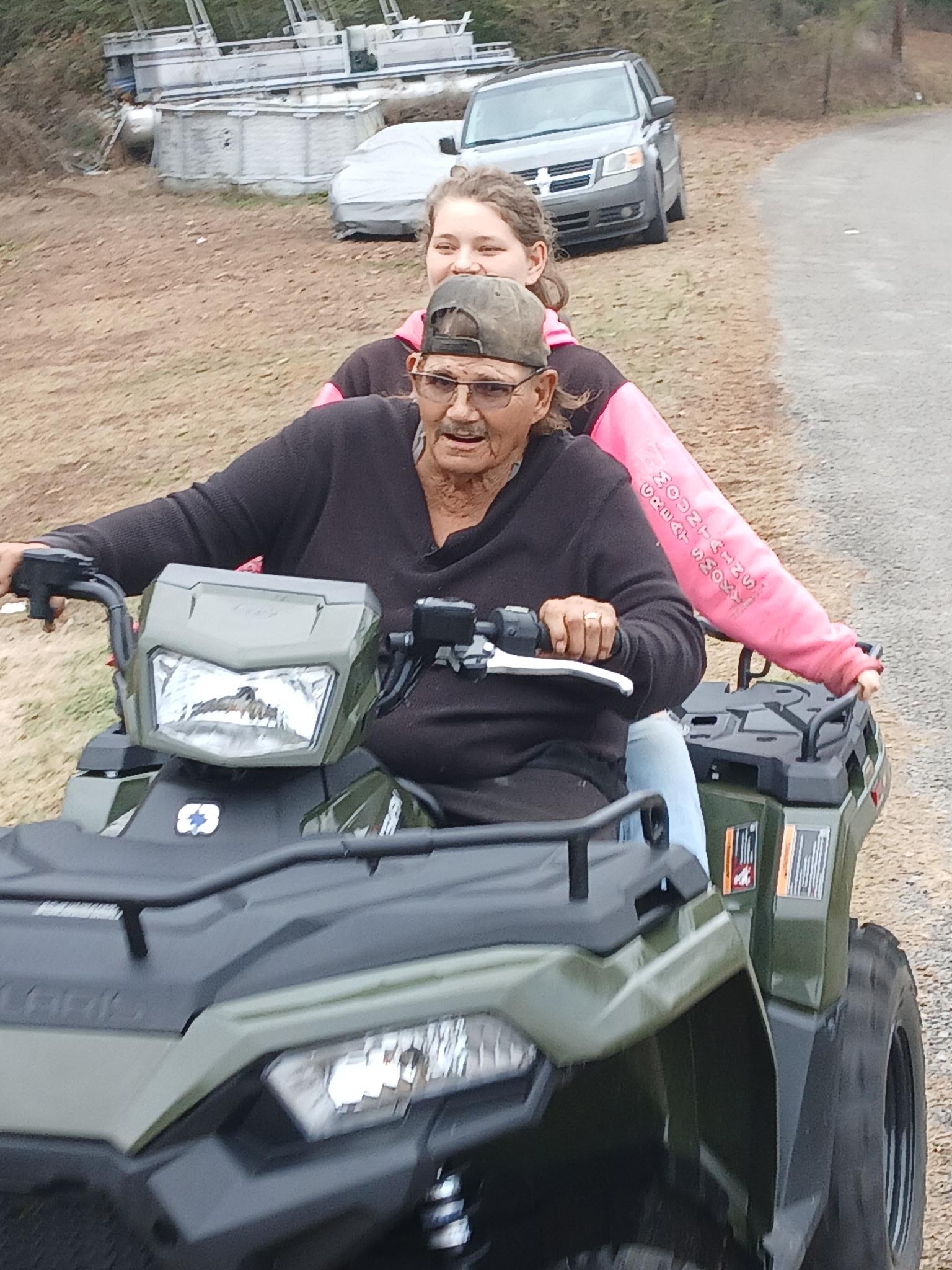 A man and woman riding on a four wheeler