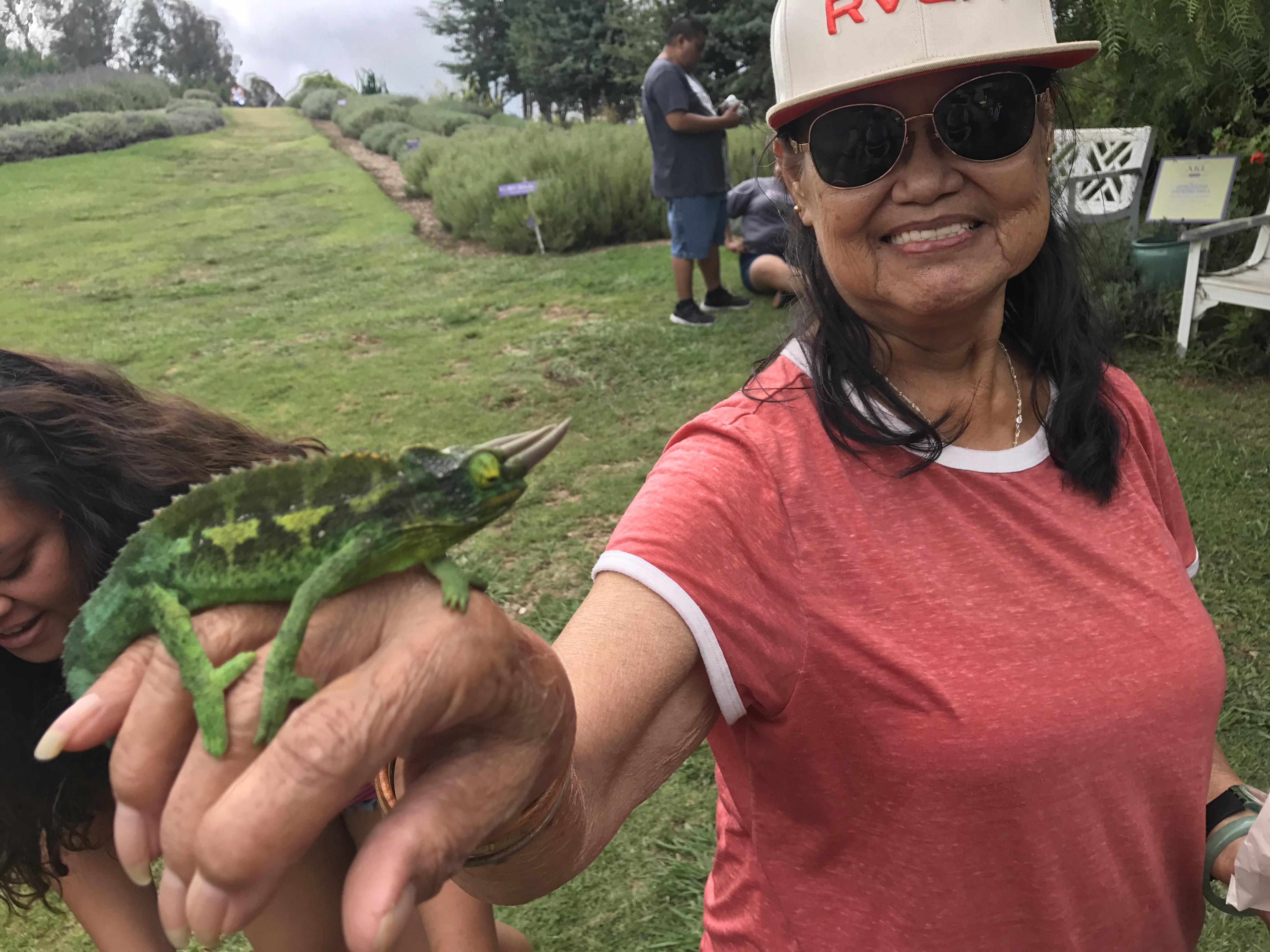 A woman holding a lizard
