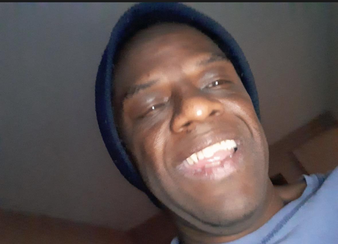 A man wearing a hat smiling