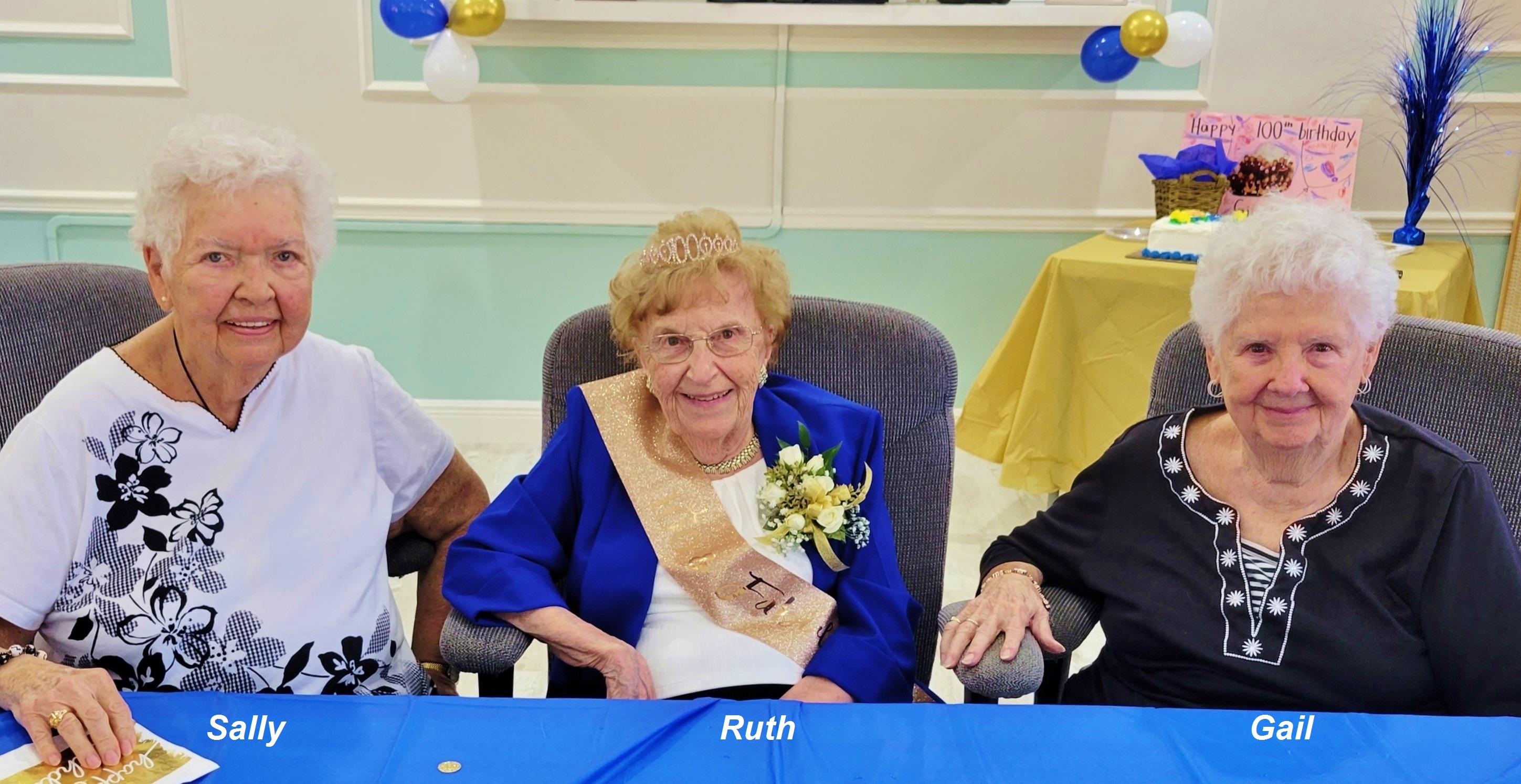 Ruth enjoys her birthday celebration with two friends at a community center.