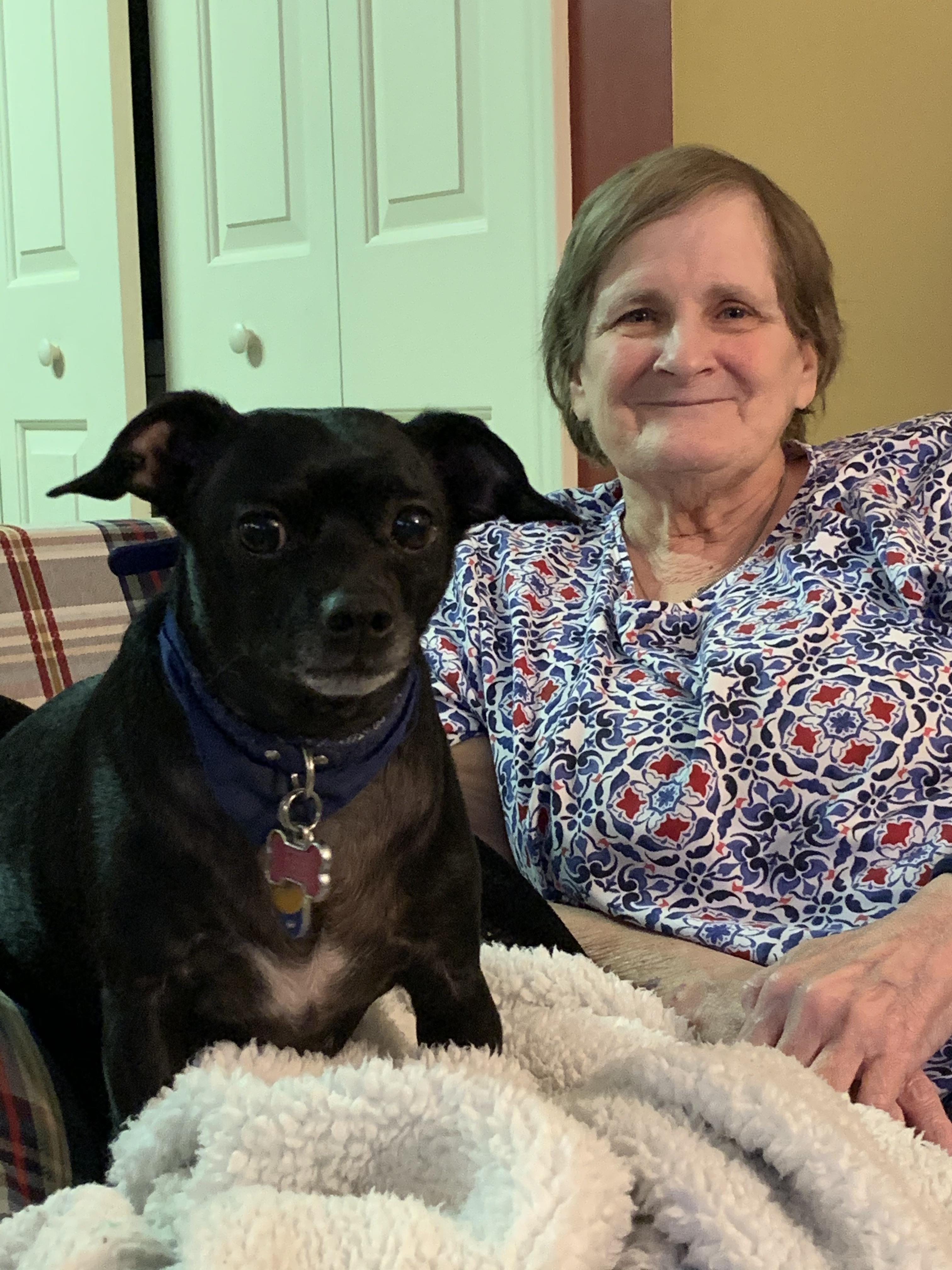 A woman sitting on a couch with a dog