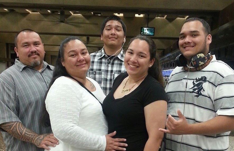 Friends stand close together, smiling and having fun inside a large indoor area.