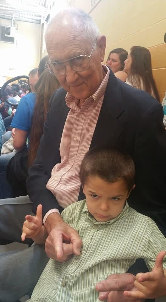 A man and a young boy are together in a crowded space with many people nearby.