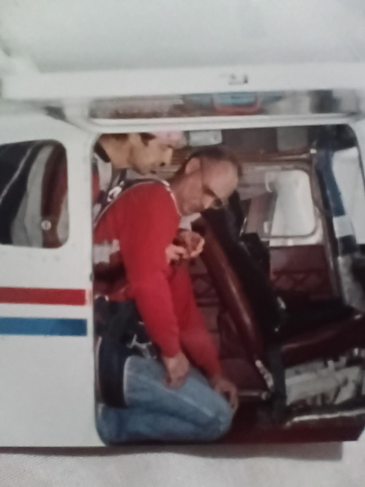 A man gets ready to jump out of a small plane with help from an instructor in bright weather.