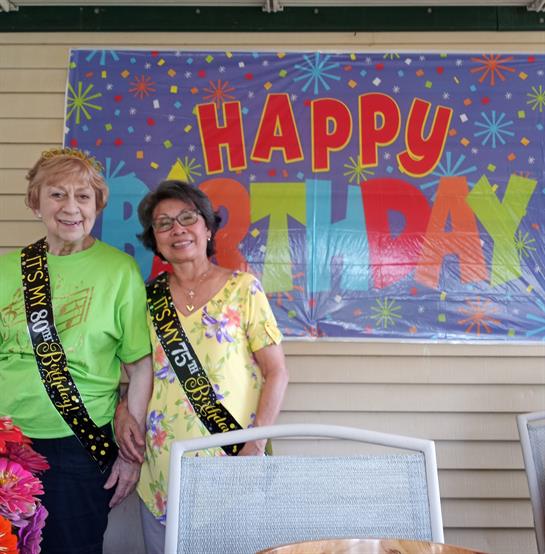 A couple of women standing in front of a banner