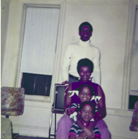 Four people pose together in a living room, smiling and enjoying each other's company while seated.