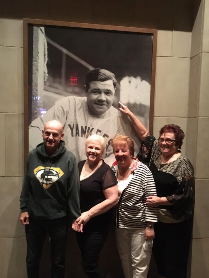 A group of people standing in front of a picture of a man