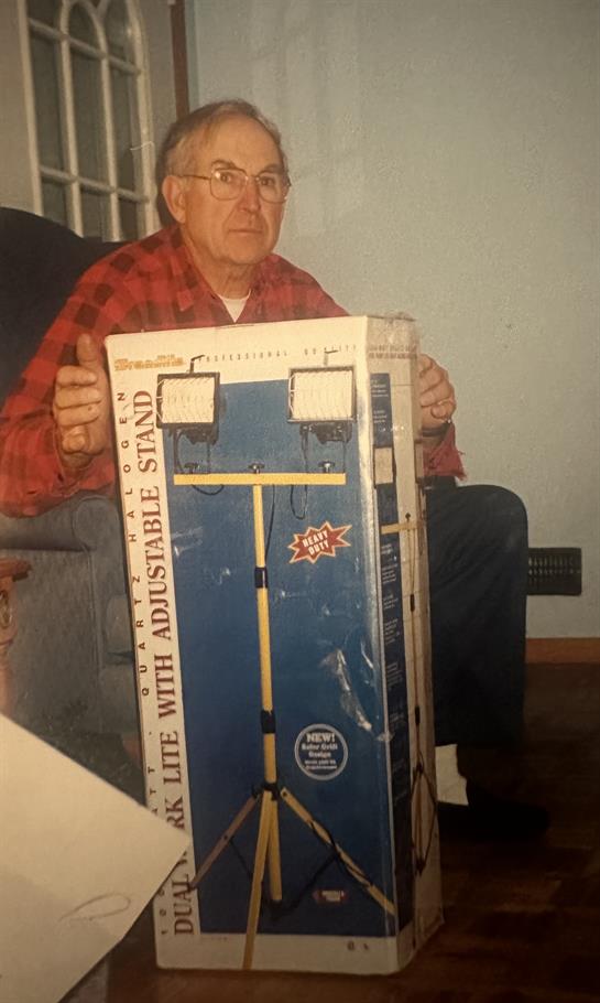 A man sitting in a chair holding a box