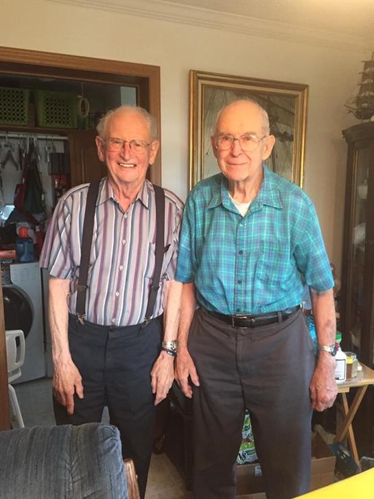 Two old men standing in a room