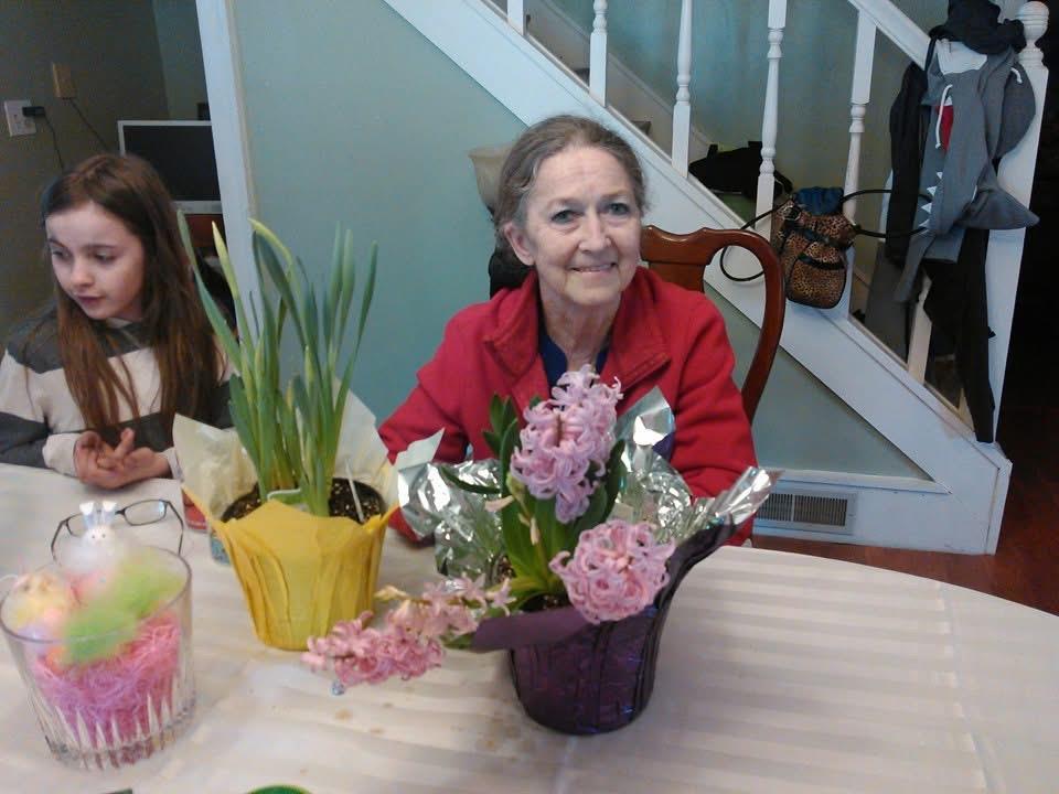 A woman sitting at a table with flowers