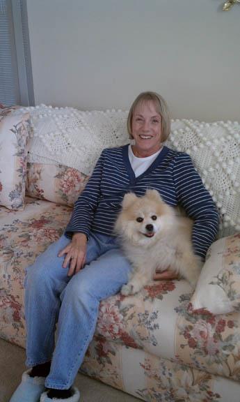 A woman sitting on a couch with a dog