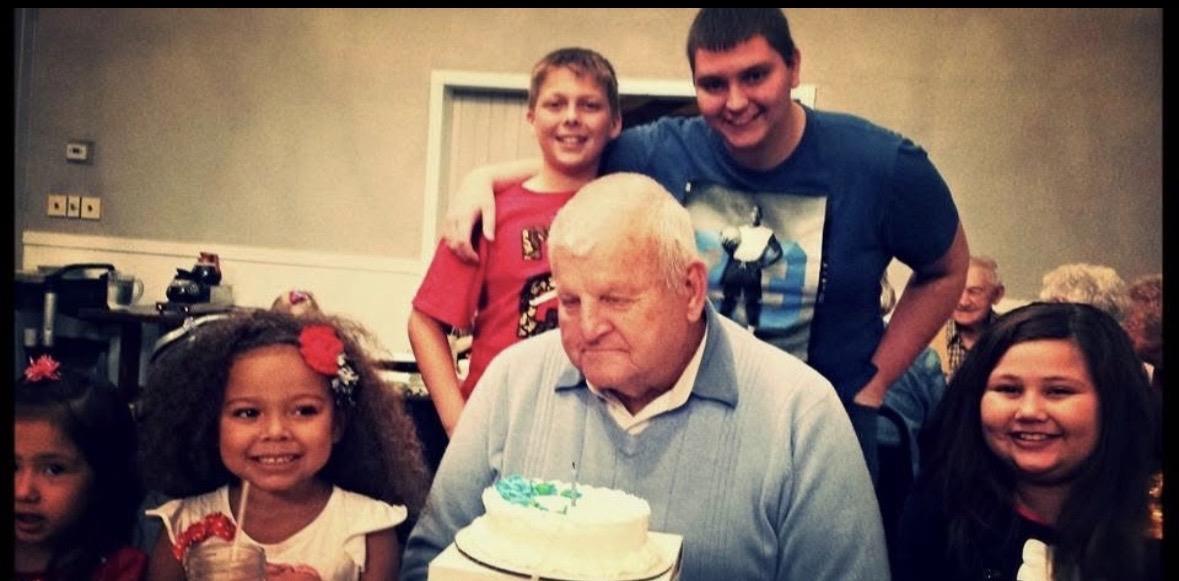 A group of people around an old man