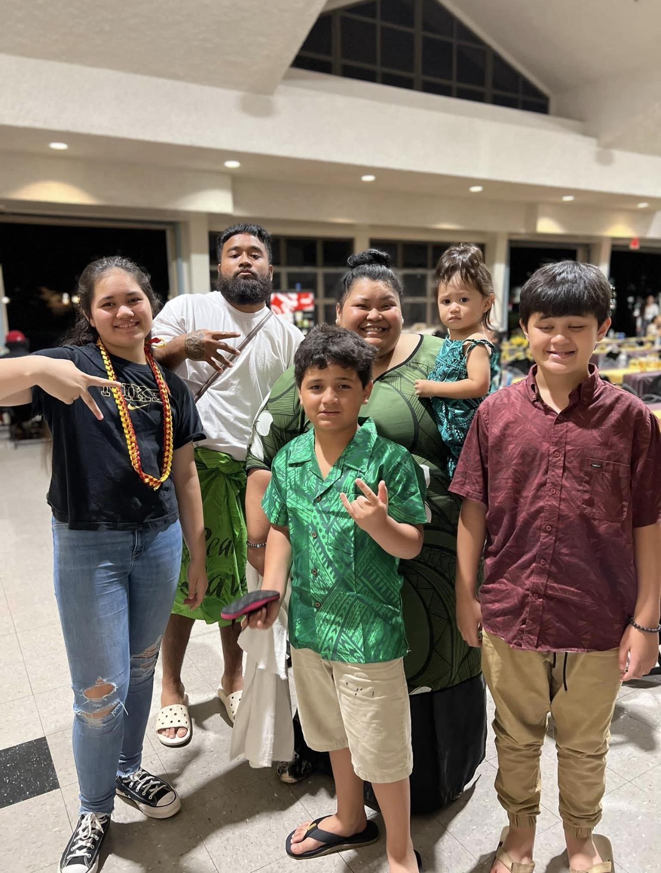 A group of six people stands close together at a community event.