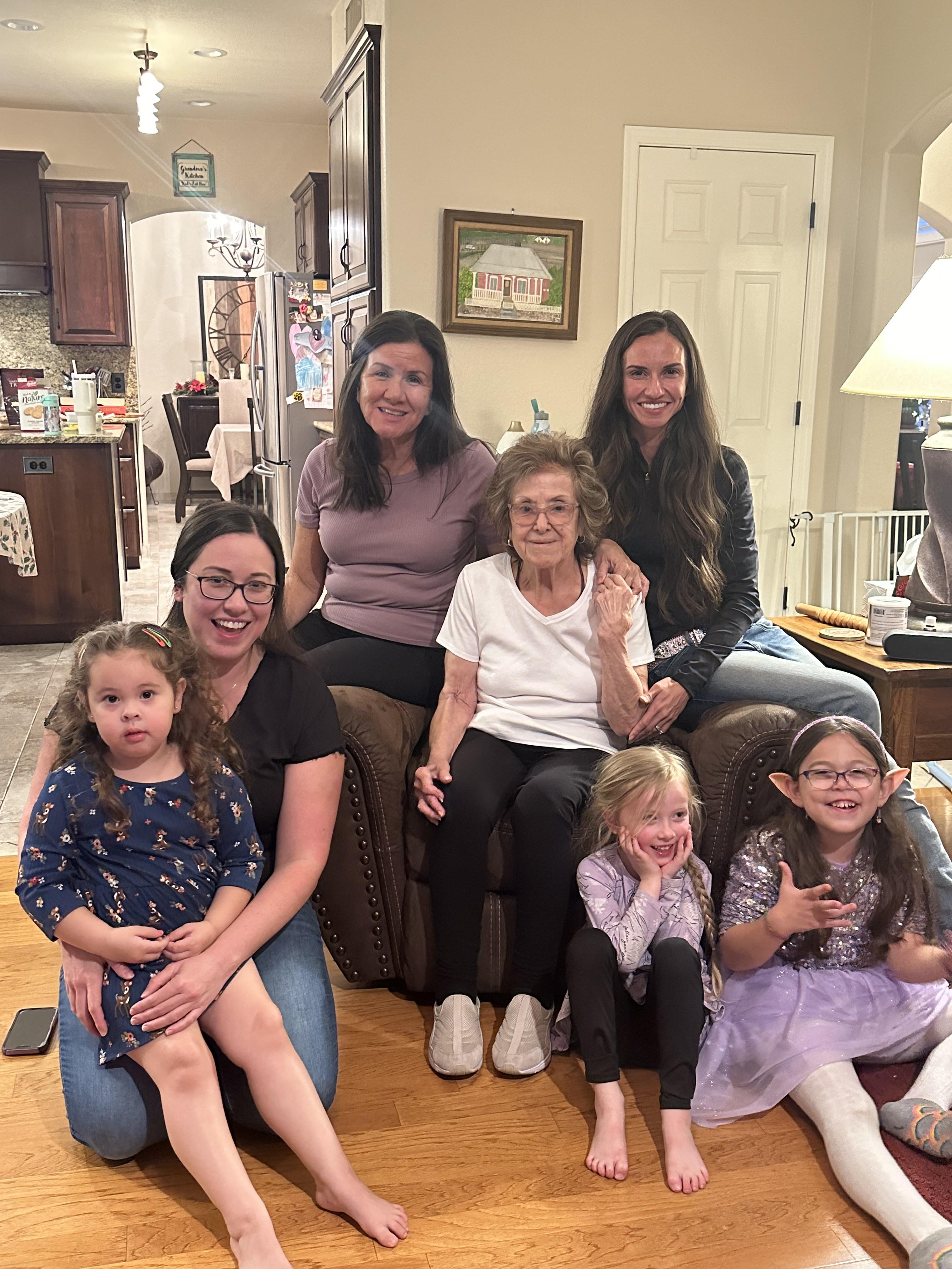 Young girls and their mothers smile with a grandmother, enjoying quality time together.