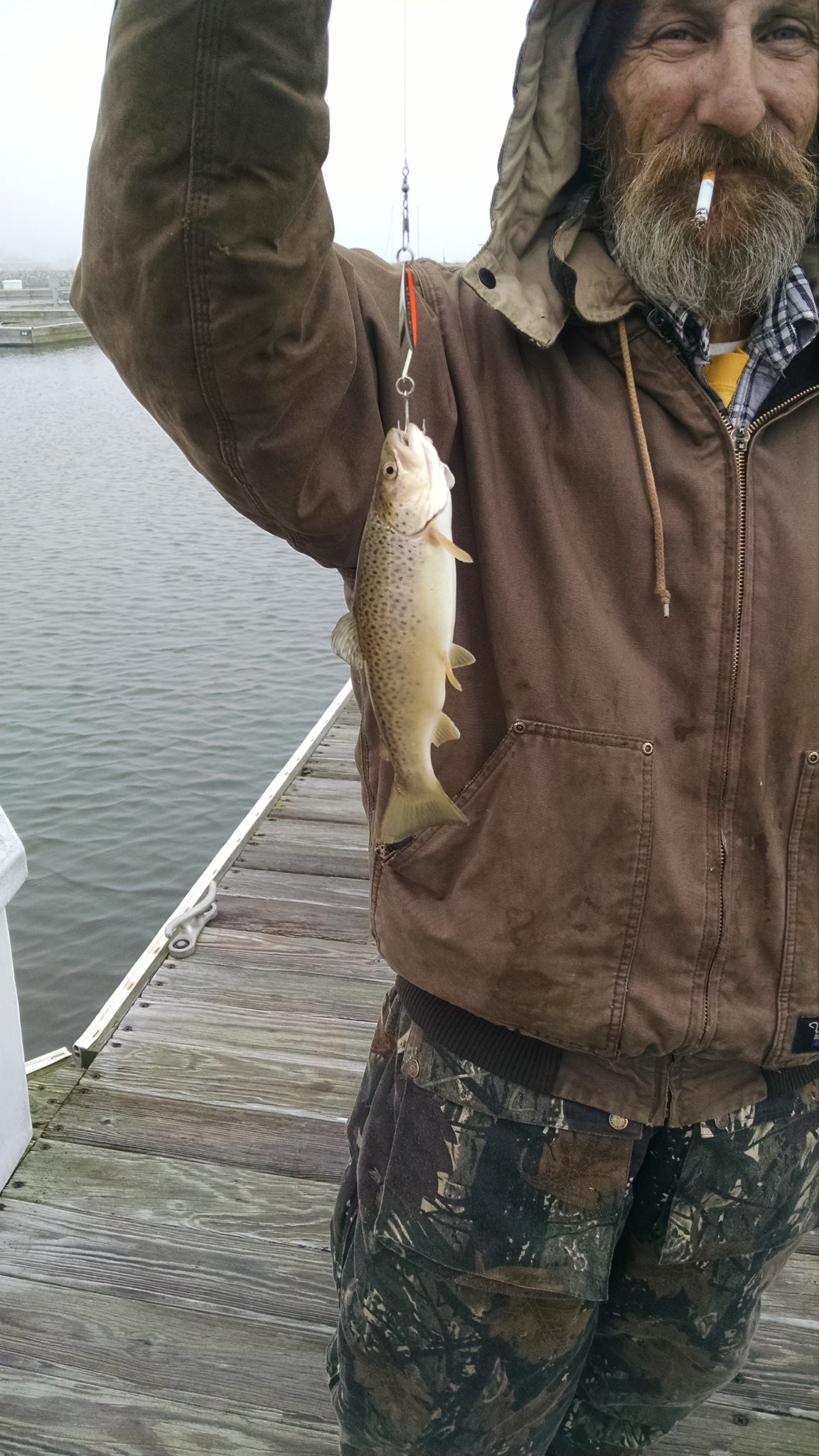 A man holding a fish on a hook