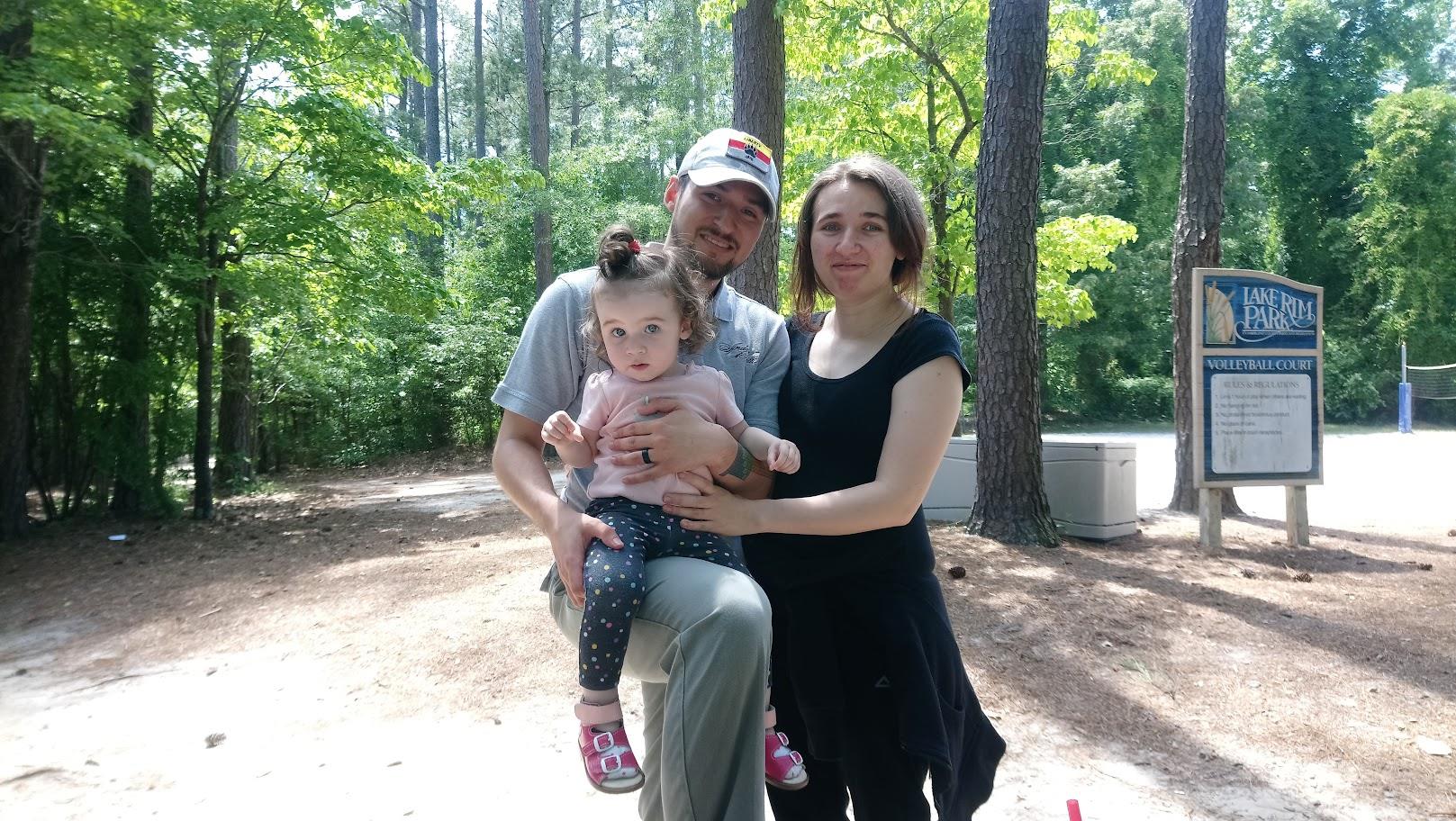 A man and woman holding a child