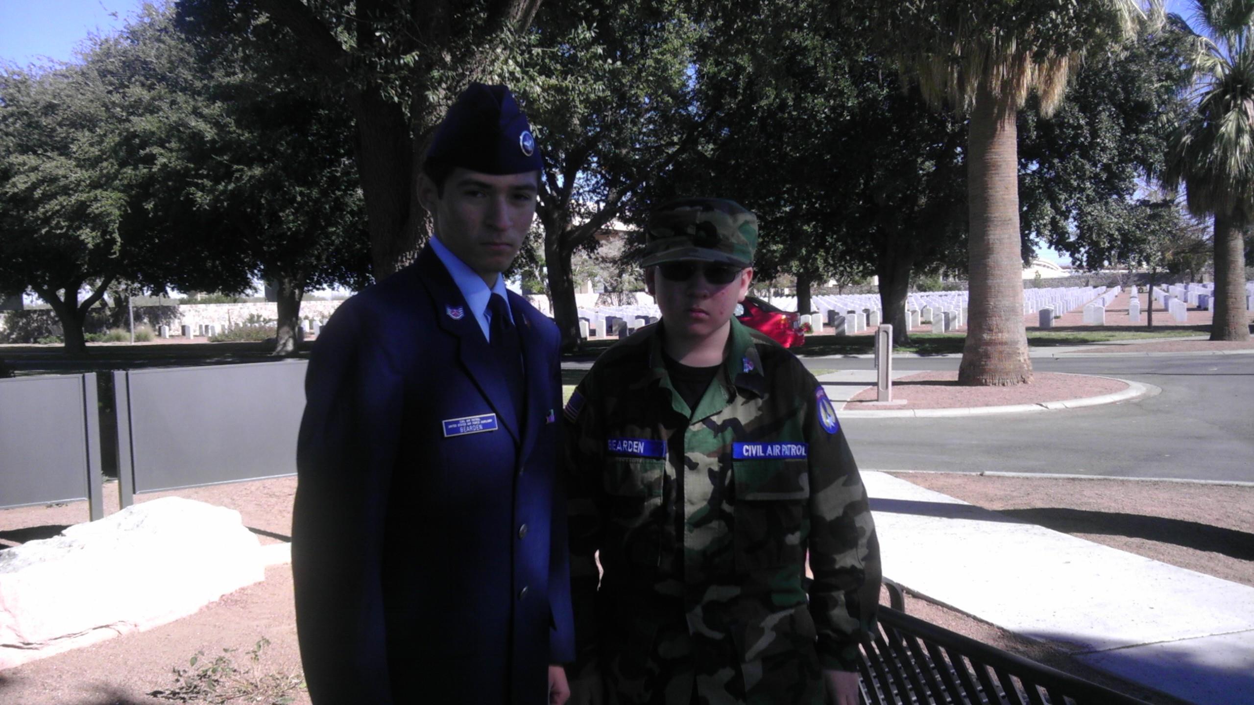 A man in uniform standing next to a woman in a park