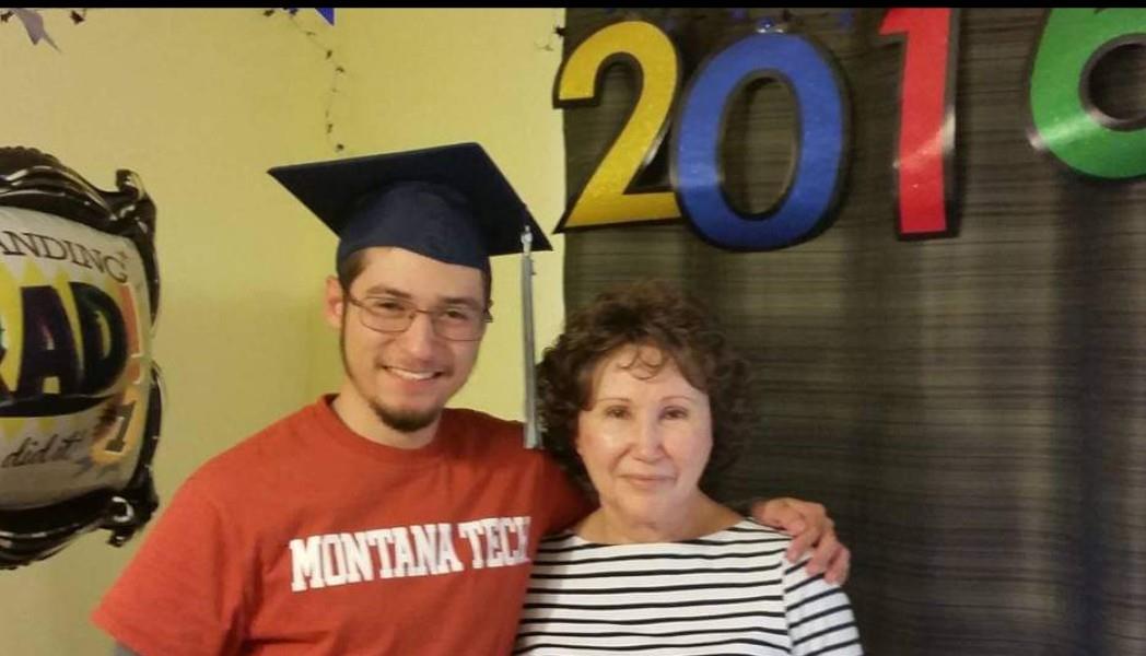 A man in a cap and gown posing with a woman