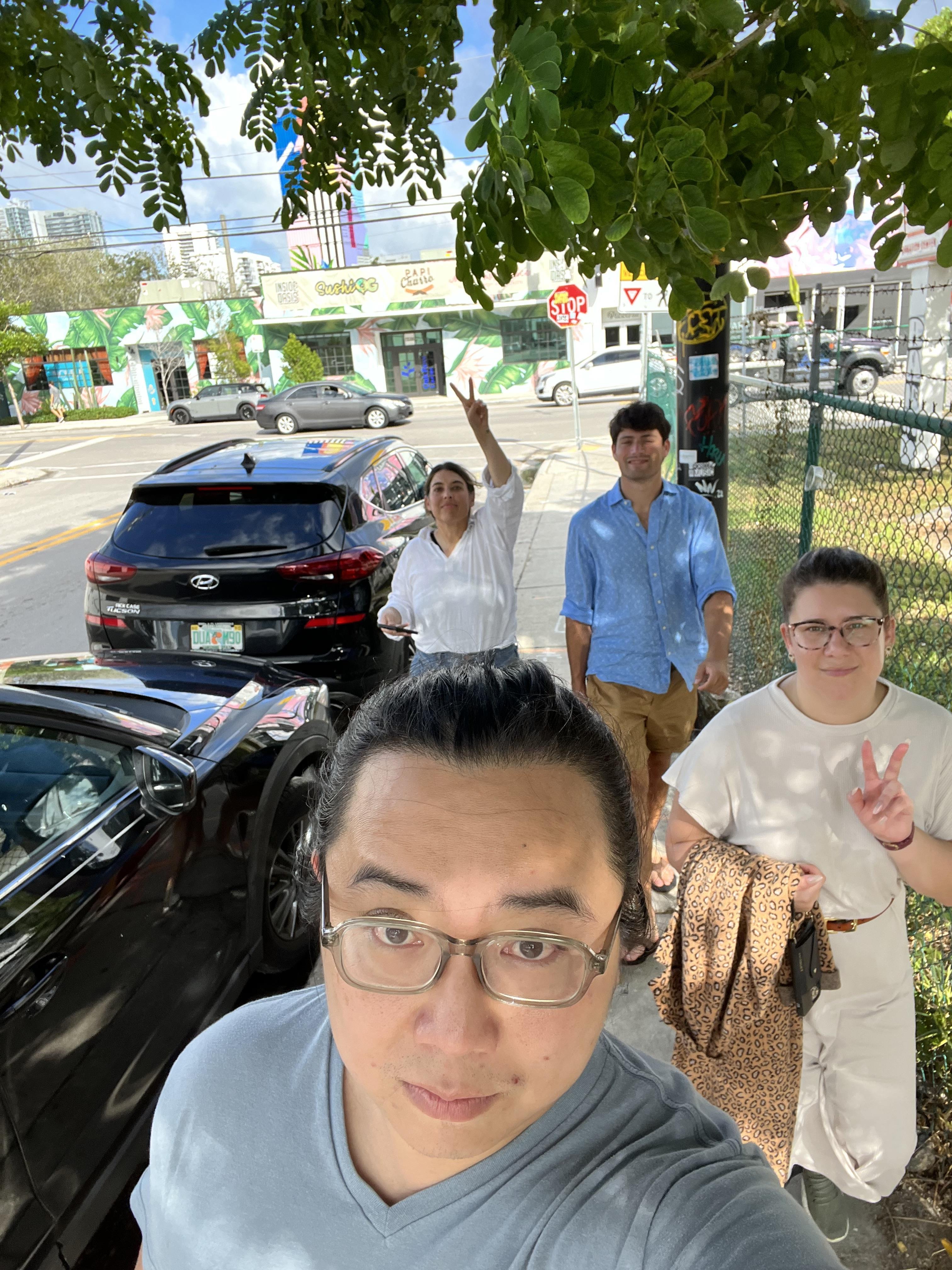 A group of people standing on a sidewalk