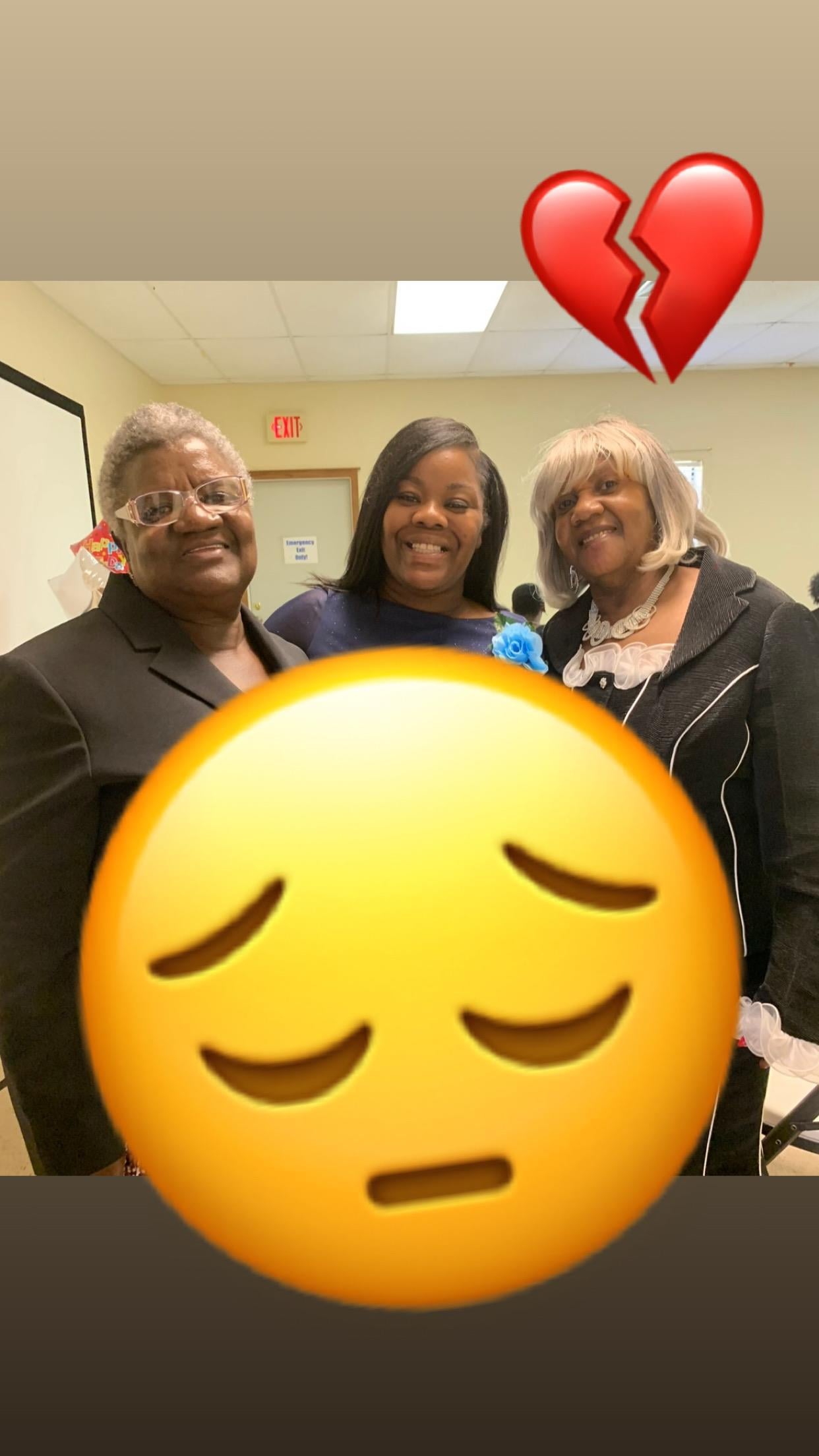 Three women smile for the camera at a gathering in a well-lit space.