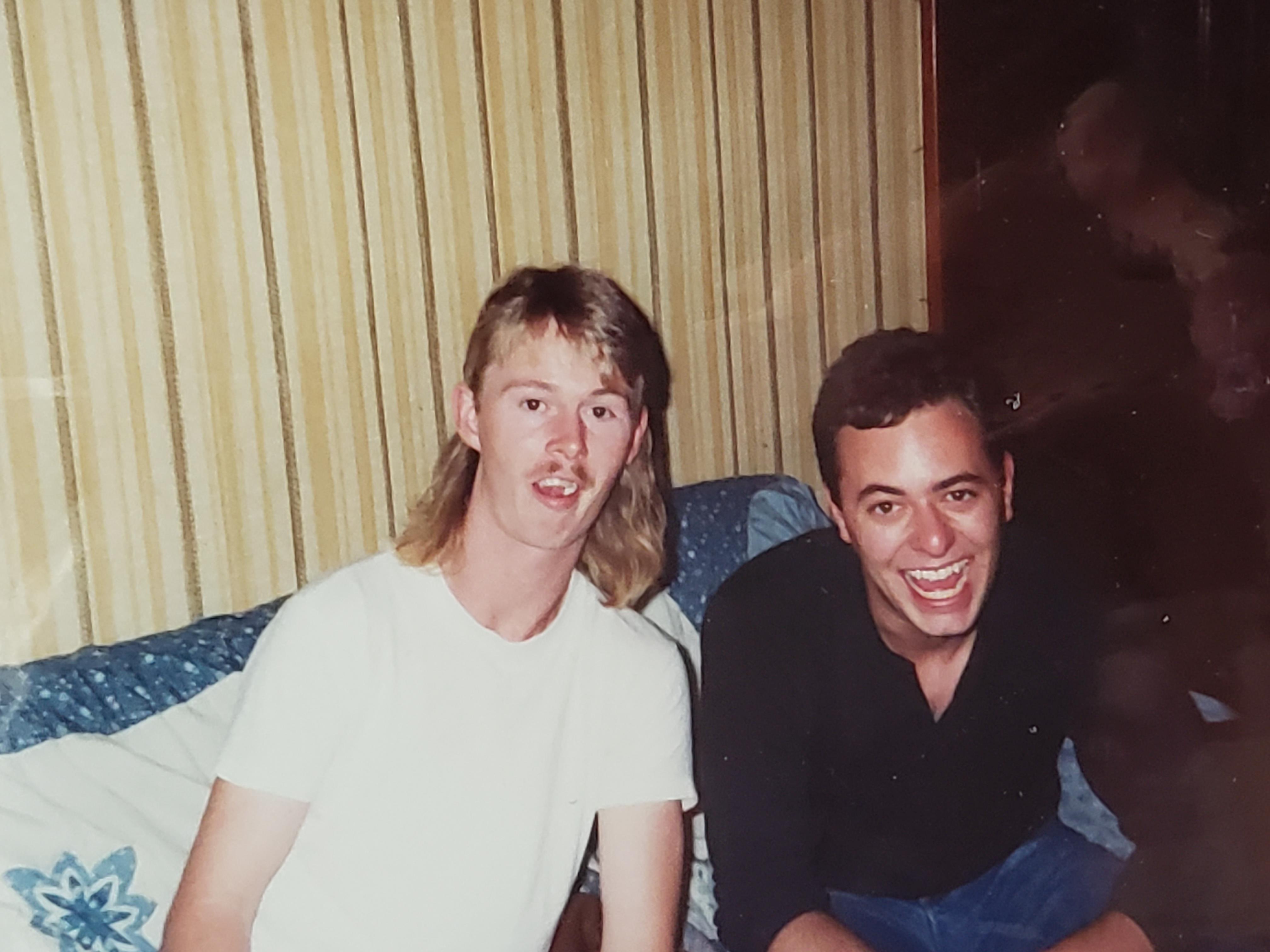 Two men sitting on a bed