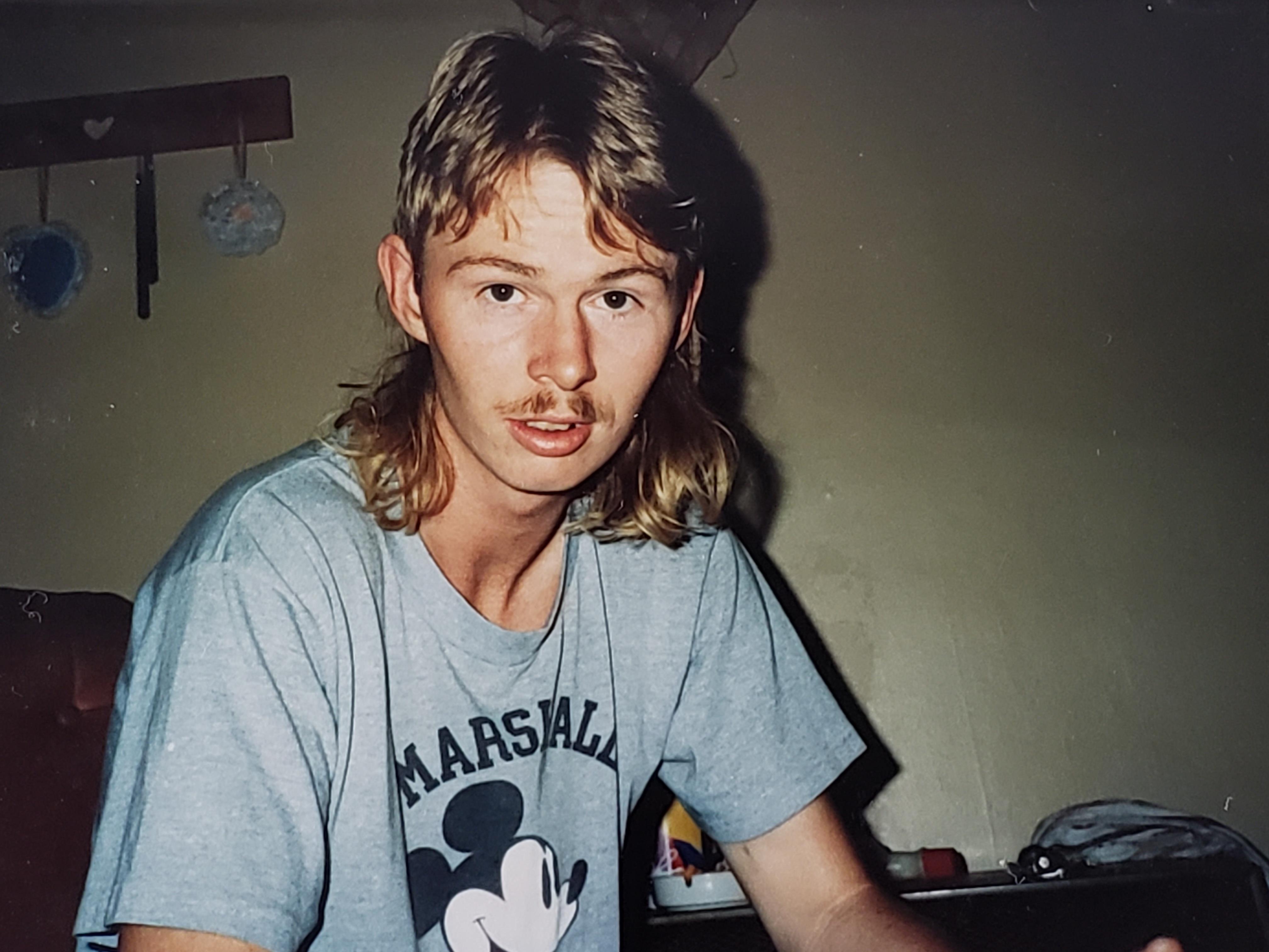 A man with long hair and a mustache