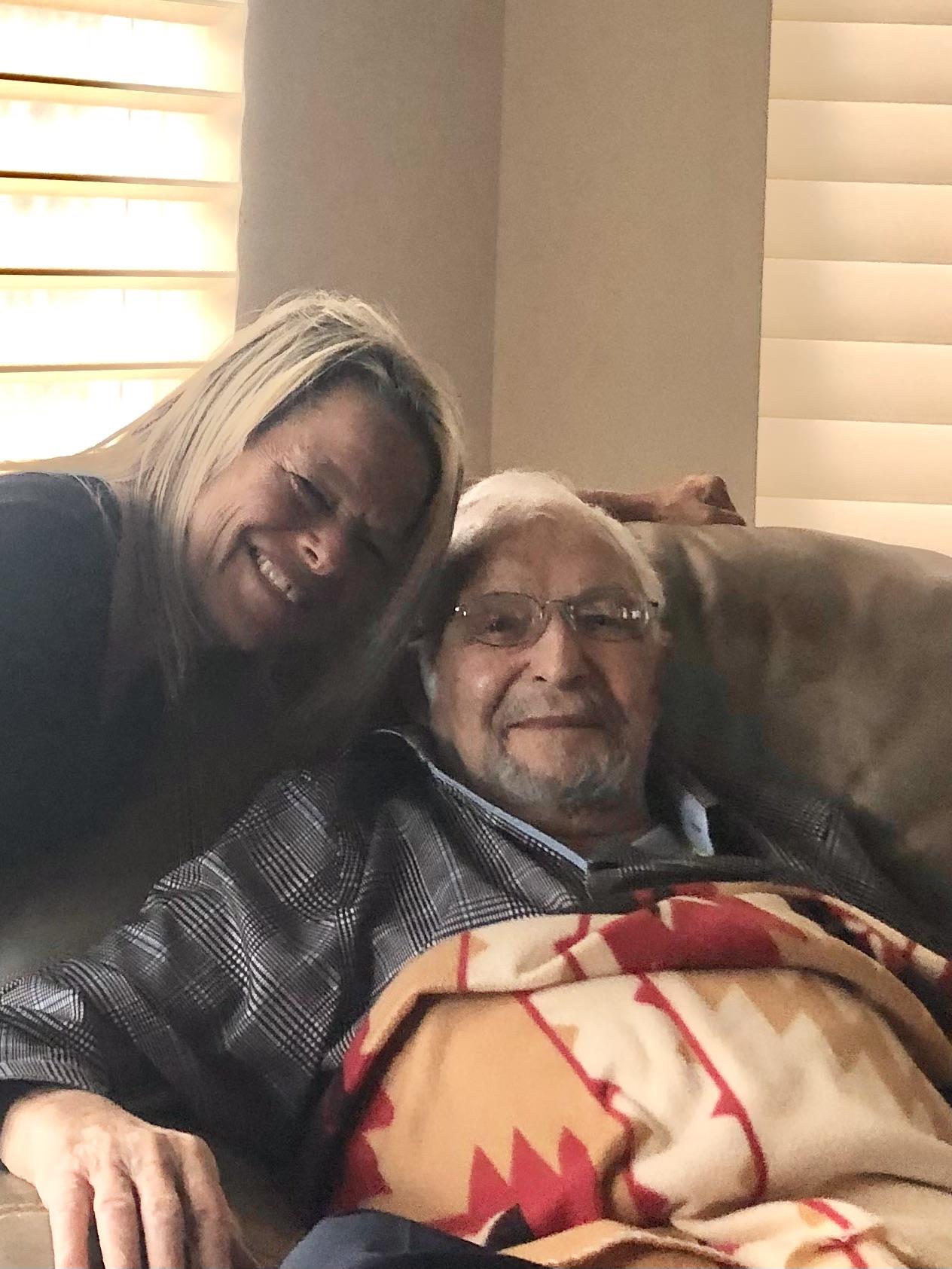 A woman leaning over a man on a couch