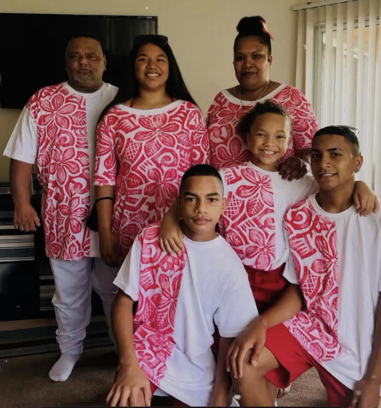 Family members enjoy a fun moment together while wearing similar clothing at home.