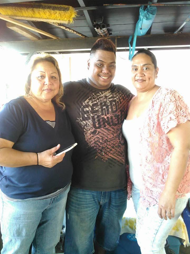 Three friends smile and enjoy each other's company at an afternoon social event.